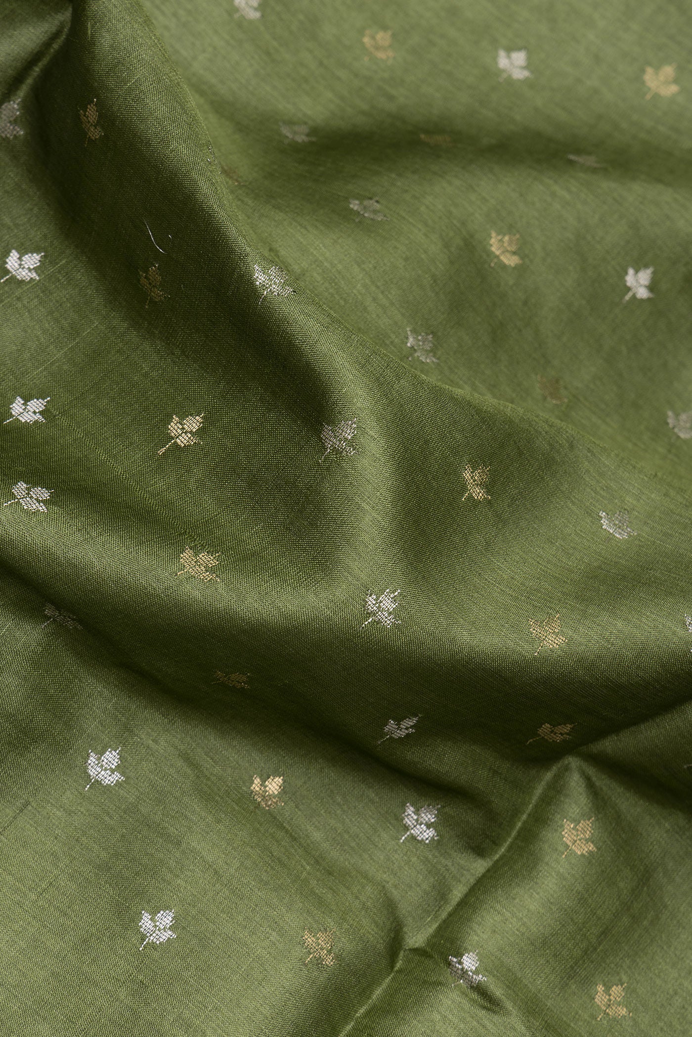 Close up of Mehandi Green Dual Tone Tussar Silk Saree with Zari Butta on the body and Zari Border.  displaying folds