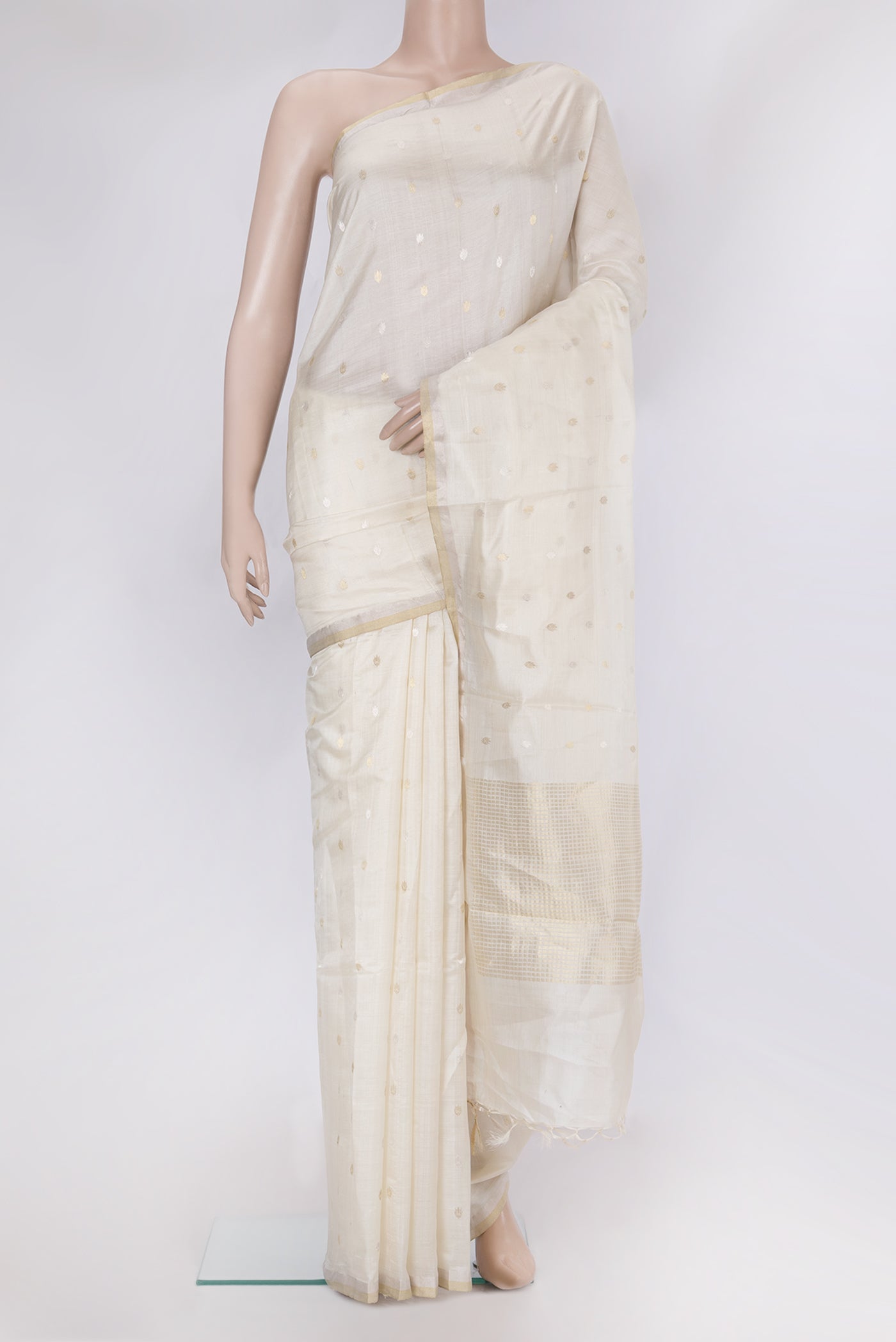 Off White Tussar Silk Saree with Zari Butta on the body and Zari Border.  displayed on a mannequin