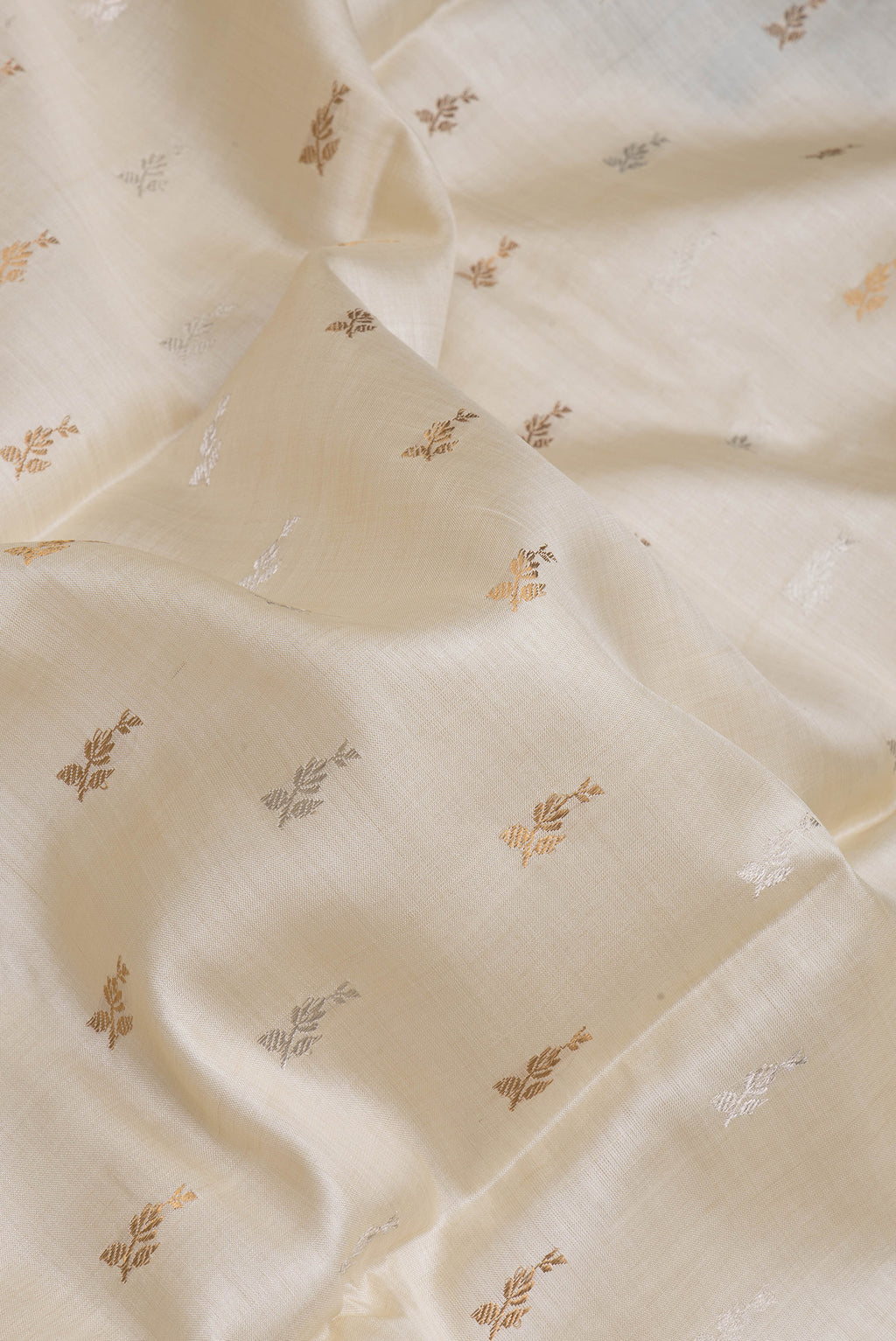 Close up of Off White Dual Tone Tussar Silk Saree with Zari Butta on the body and Without Border.  displaying folds