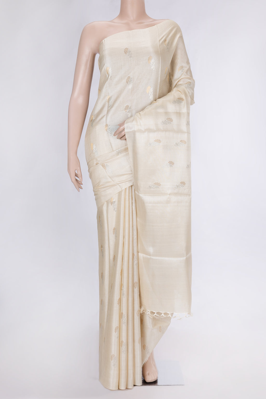 Beige Dual Tone Tussar Silk Saree with Zari Butta on the body and Without Border.  displayed on a mannequin