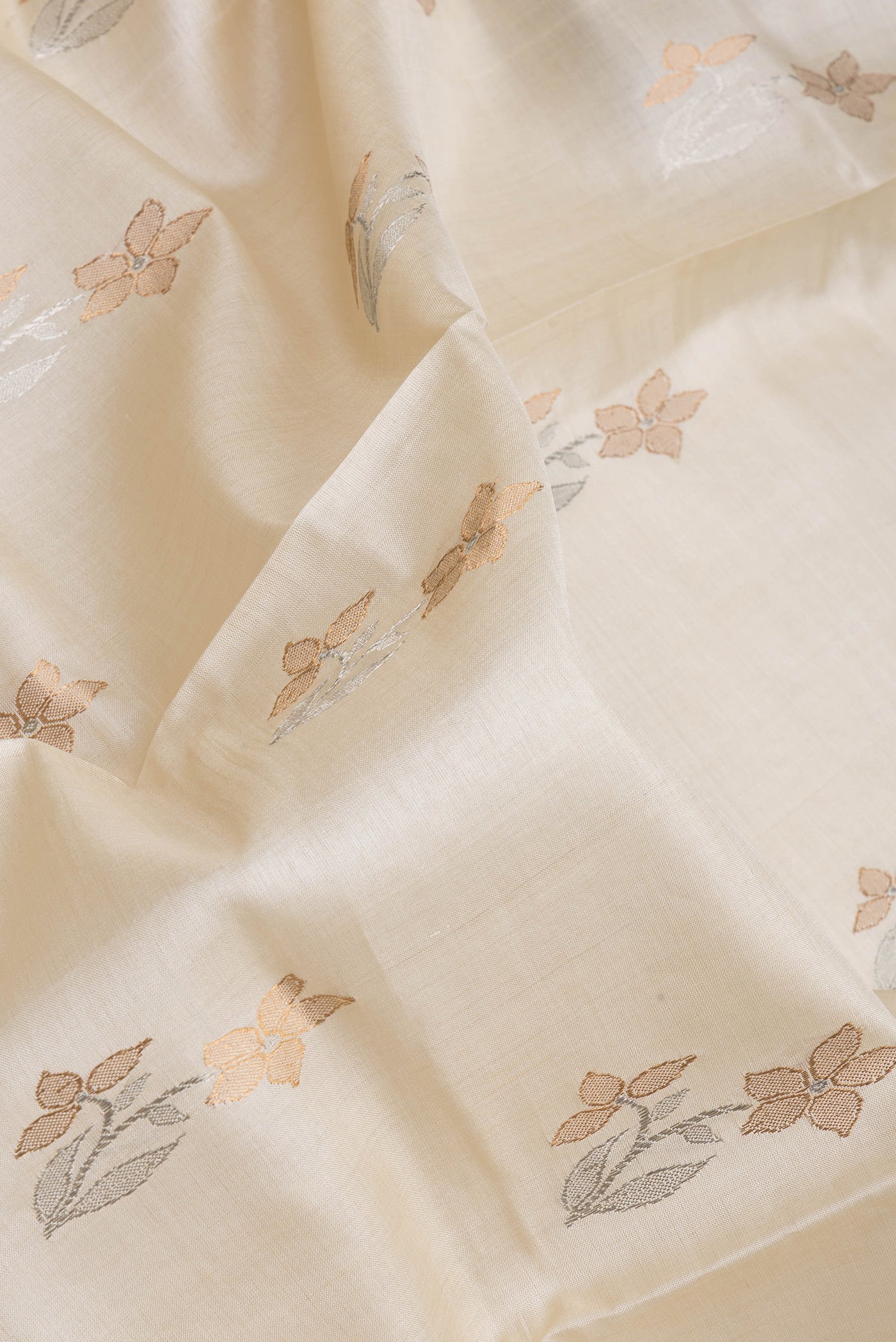 Close up of Off White Tussar Silk Saree with Zari Butta on the body and Without Border.  displaying folds