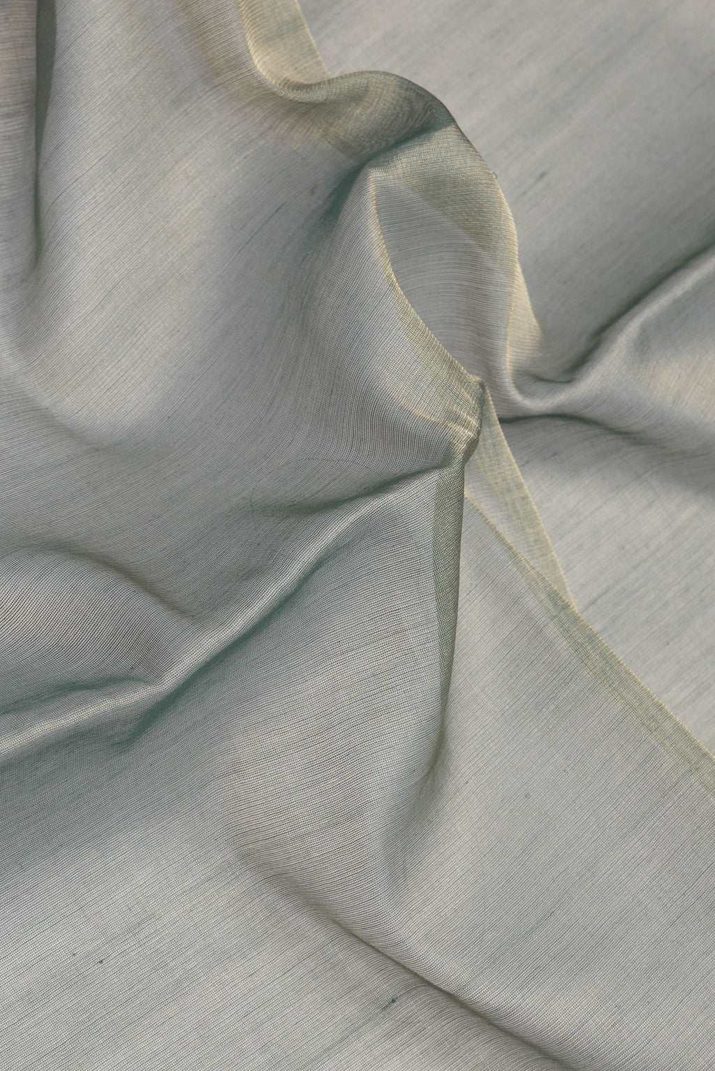 Close up of Green Tussar Silk Saree with Plain Body and Temple Border.  displaying folds