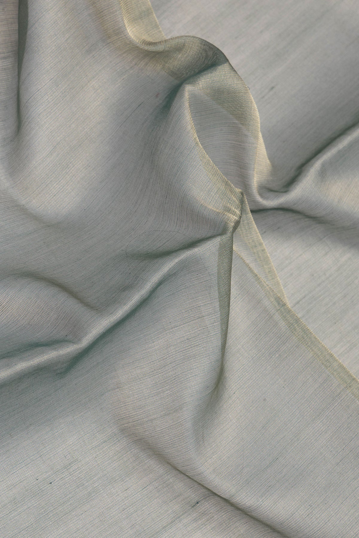 Close up of Green Tussar Silk Saree with Plain Body and Temple Border.  displaying folds
