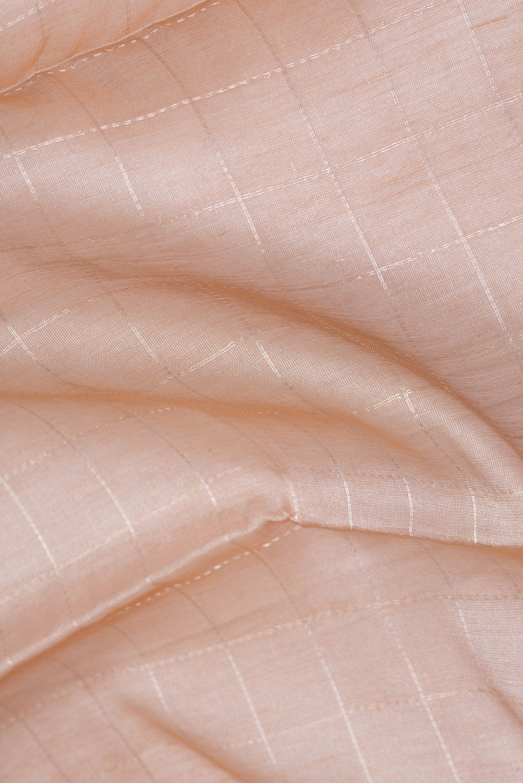 Close up of Peach Dual Tone Tussar Silk Saree with Checked design on the body and Zari Border.  displaying folds
