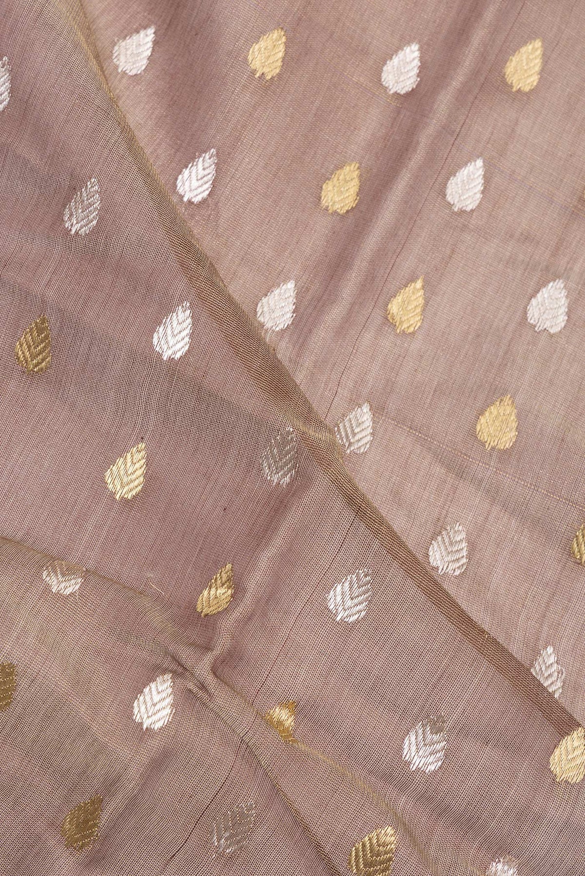 Close up of Brown Dual Tone Tussar Saree with Zari Butta on the body and Zari Border.  displaying folds