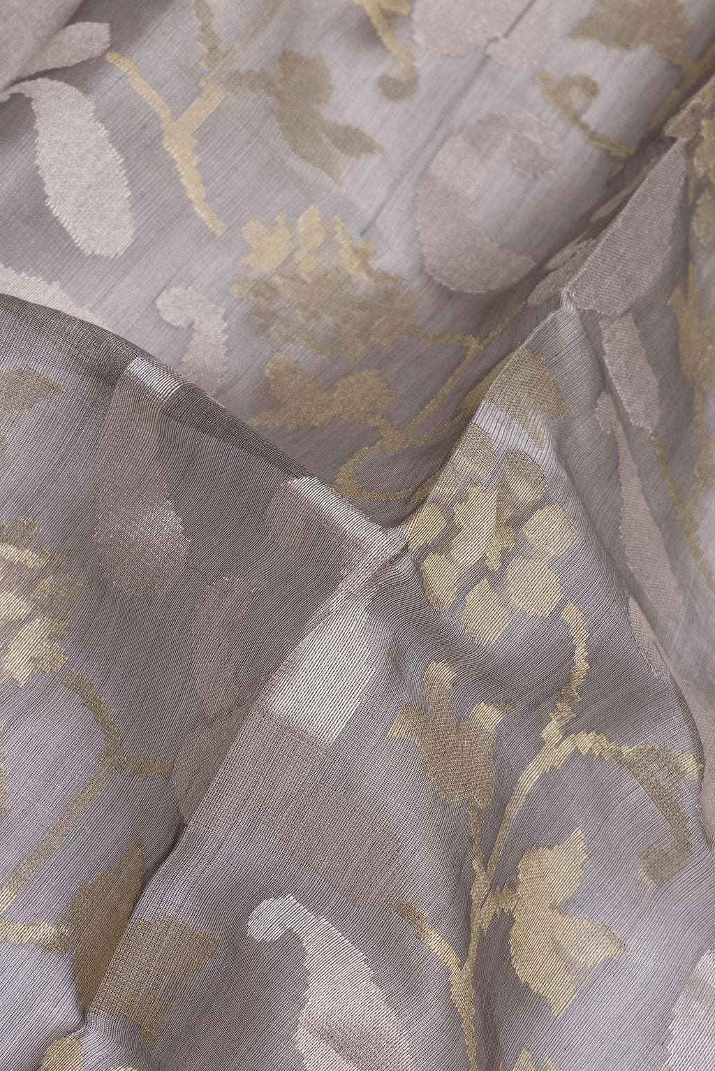Close up of Grey Tussar Silk Saree with Zari Brocade on the body and Zari Border.  displaying folds