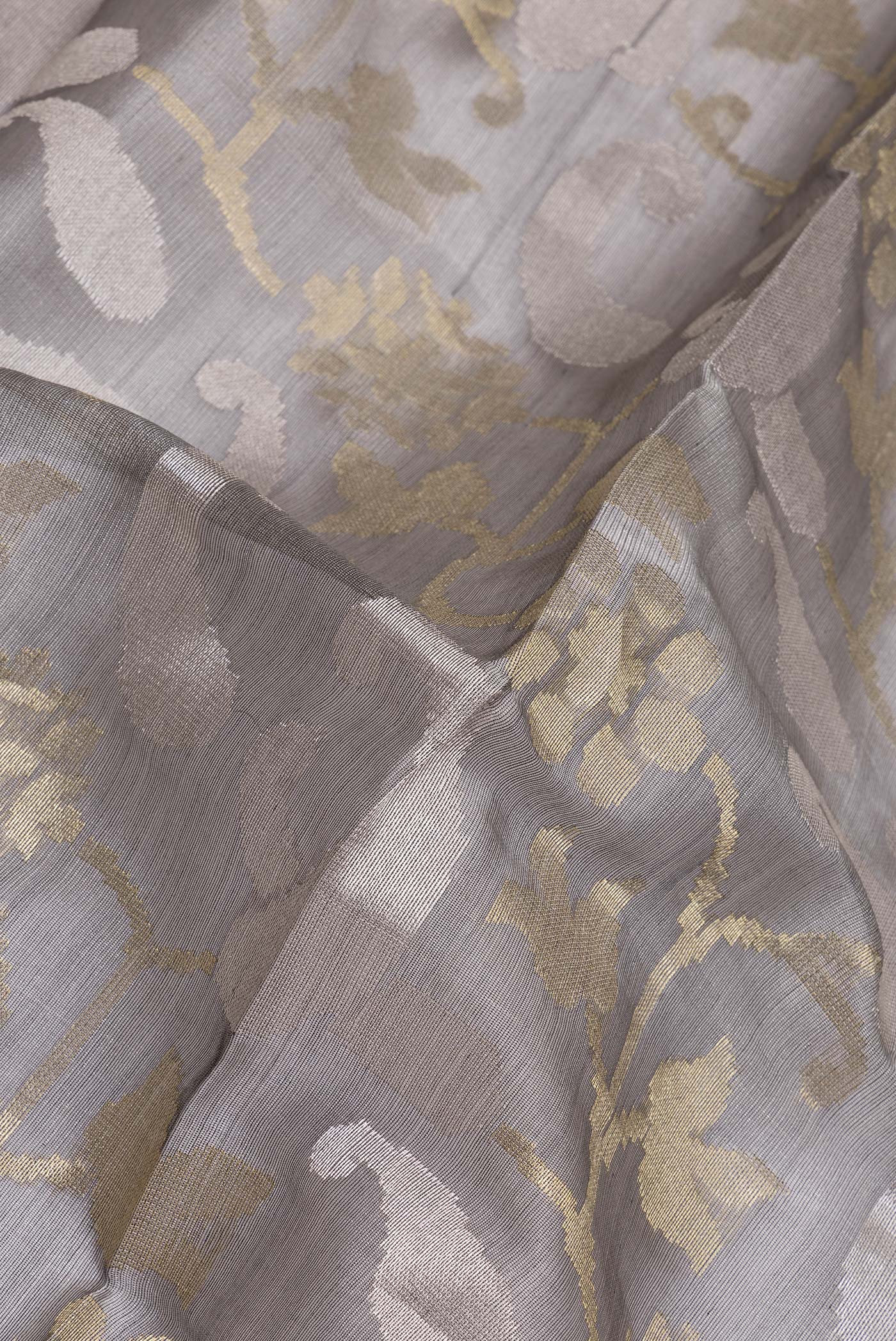 Close up of Grey Tussar Silk Saree with Zari Brocade on the body and Zari Border.  displaying folds