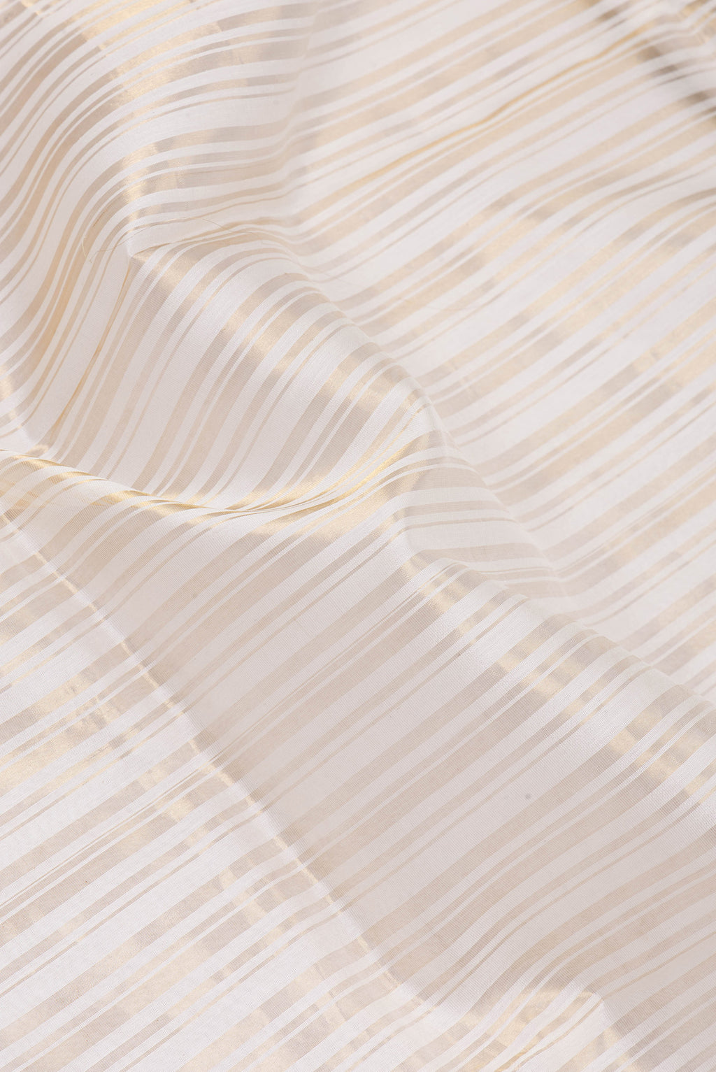 Close up of Off White Tussar Silk Saree with Stripes on the body and Thin Zari Line.  displaying folds
