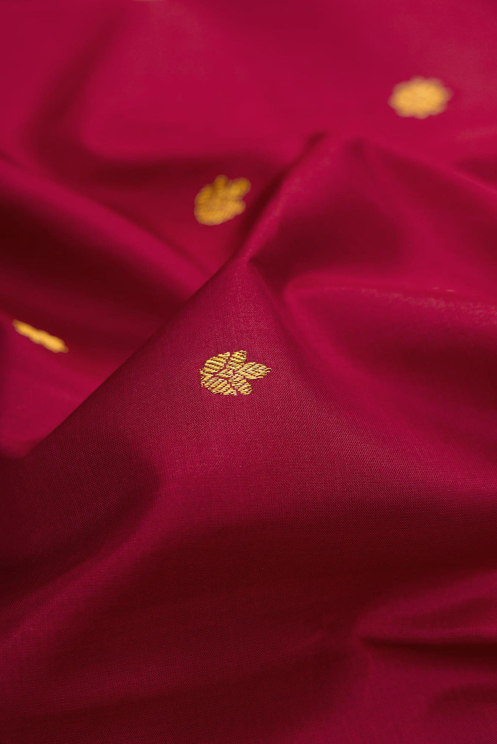 Close up of Maroon Dual Tone Kanchipuram Silk Saree with Zari Butta on the body and Zari Border.  displaying folds