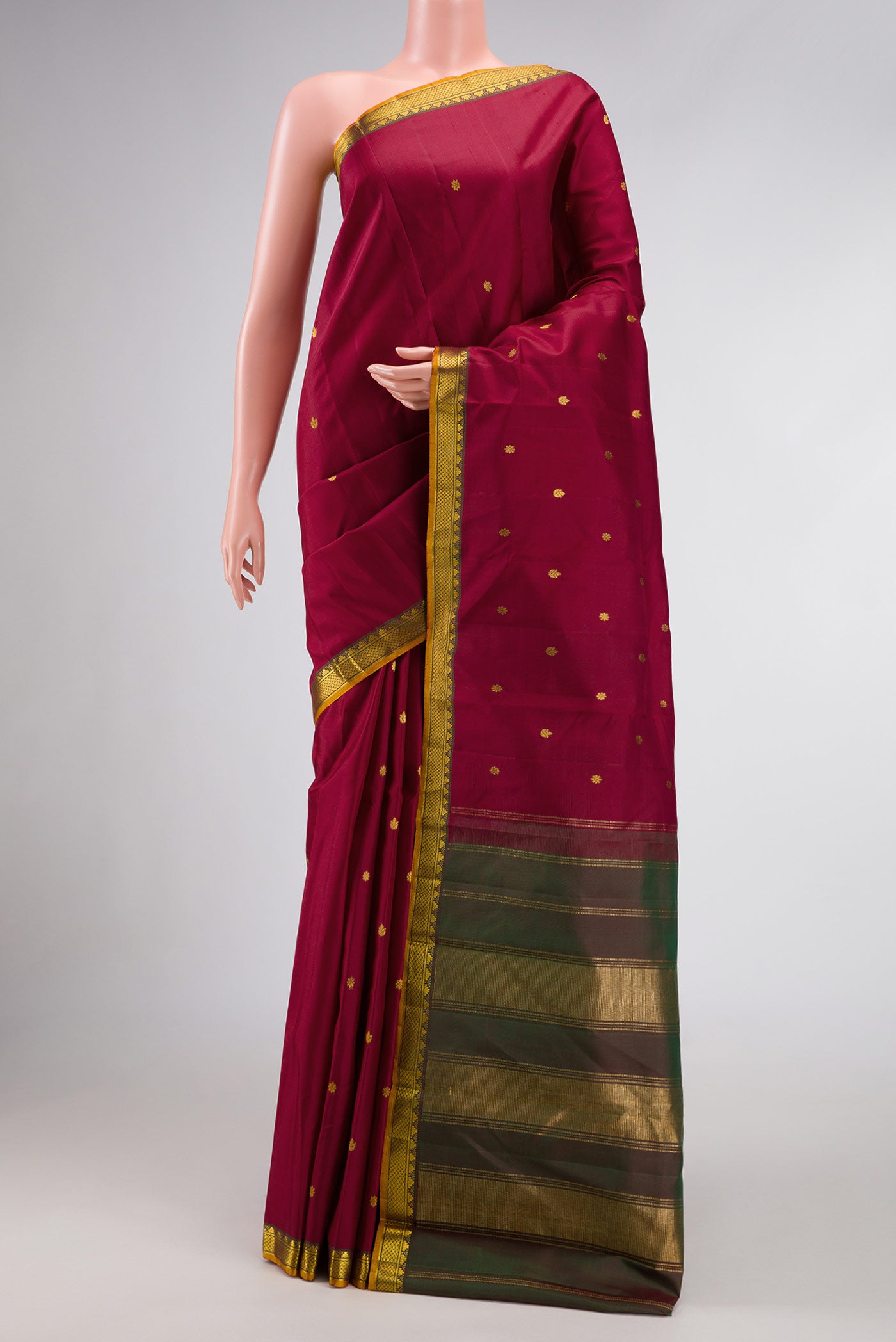 Maroon Dual Tone Kanchipuram Silk Saree with Zari Butta on the body and Zari Border.  displayed on a mannequin