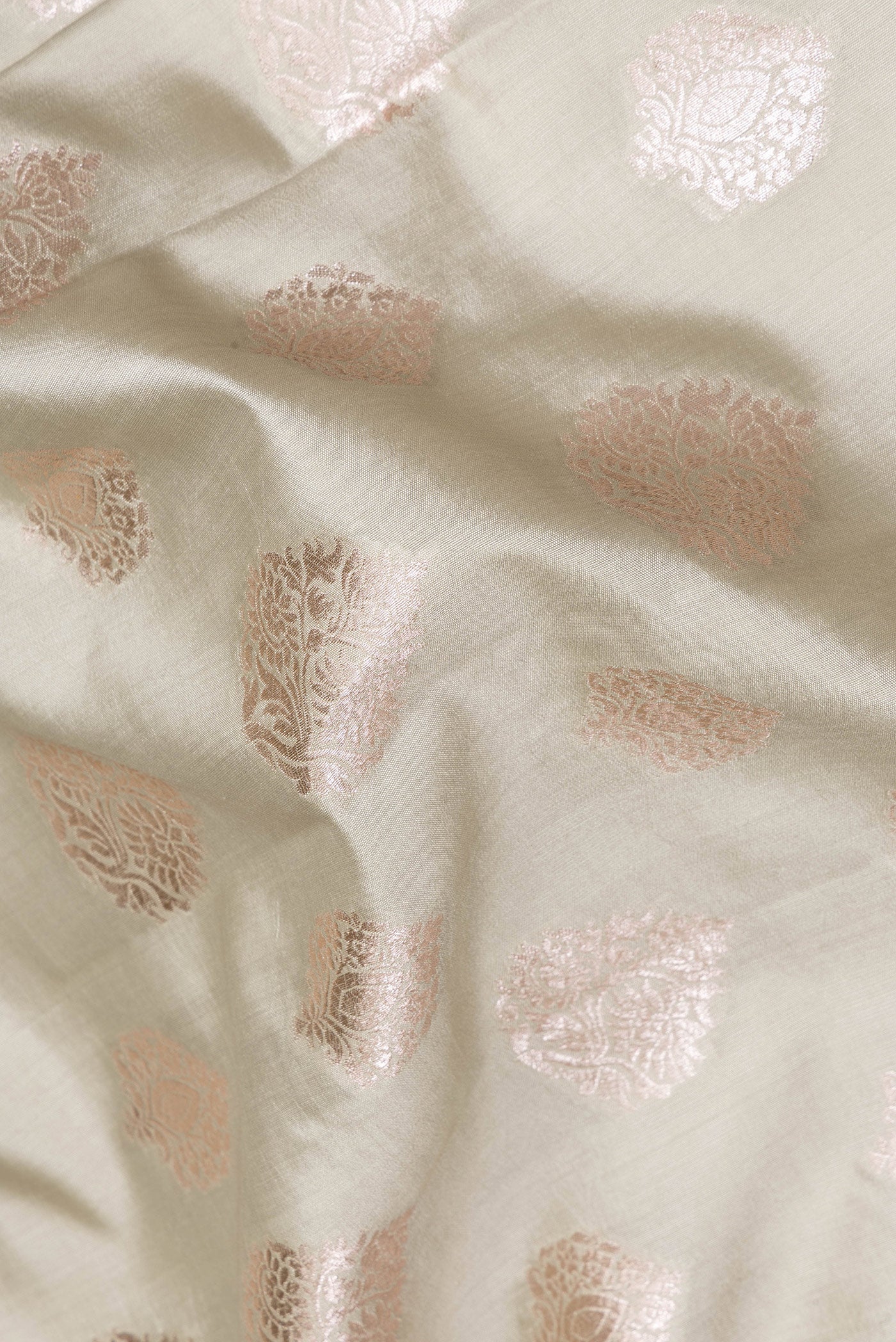 Close up of Light Green Tussar Silk Saree with Zari Butta on the body and Zari Border.  displaying folds