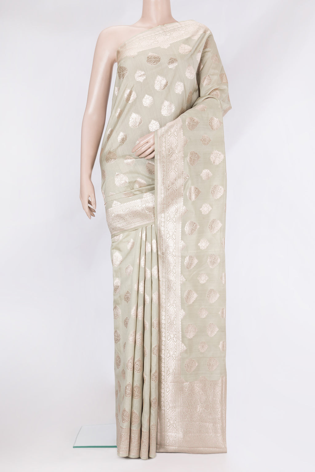 Light Green Tussar Silk Saree with Zari Butta on the body and Zari Border.  displayed on a mannequin
