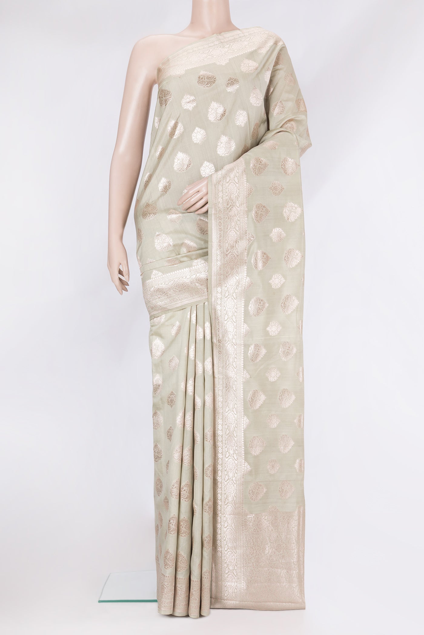 Light Green Tussar Silk Saree with Zari Butta on the body and Zari Border.  displayed on a mannequin