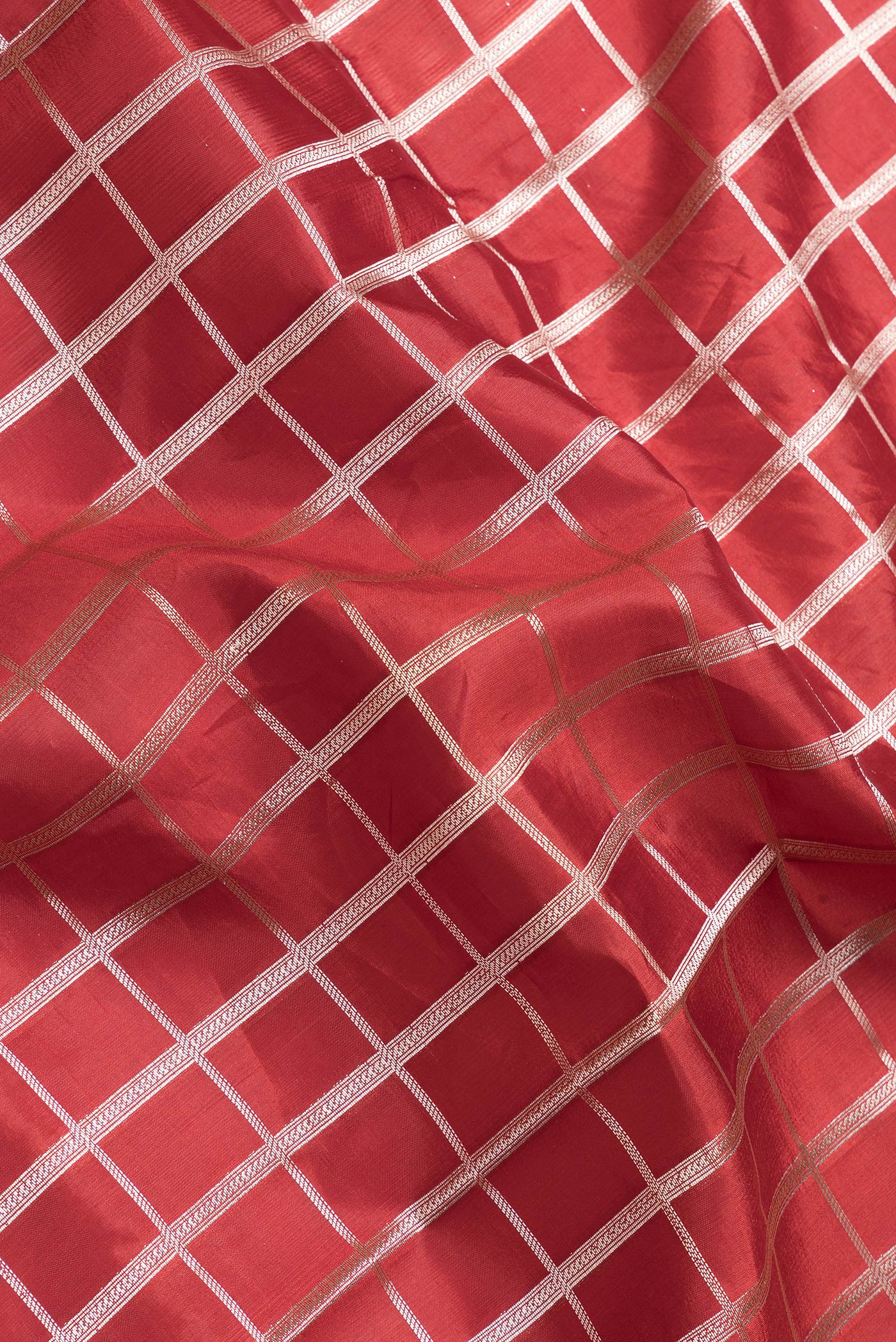 Close up of Maroon Dual Tone Tussar Silk Saree with Checked design on the body and Zari Border.  displaying folds