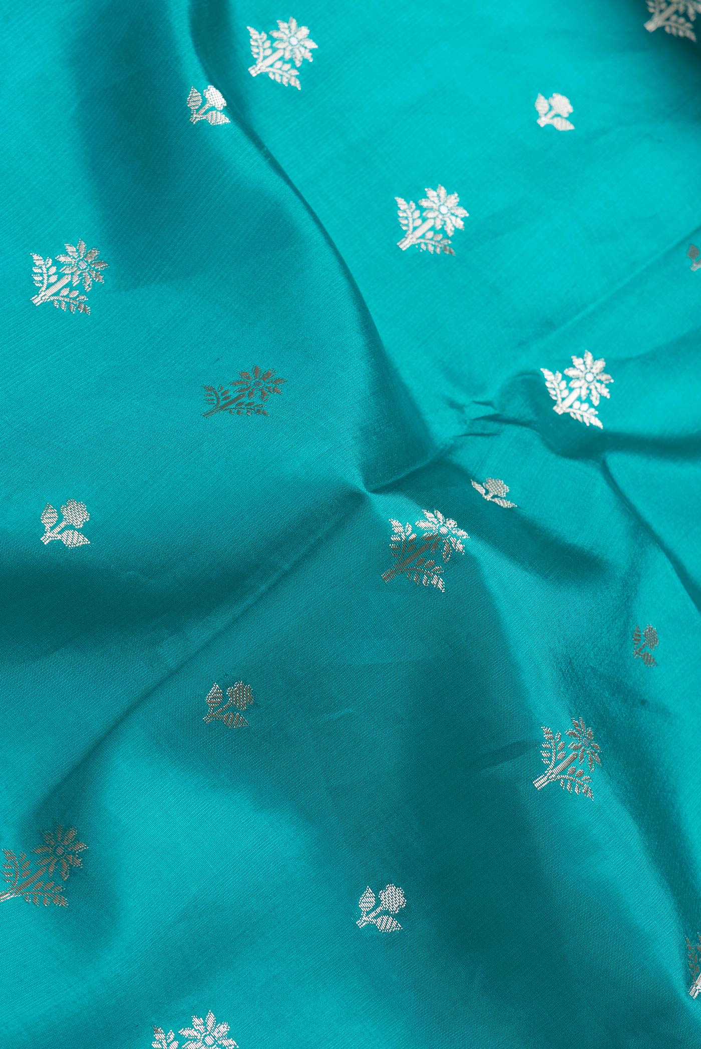 Close up of Peacock Blue Dual Tone Tussar Silk Saree with Zari Butta on the body and Zari Border.  displaying folds