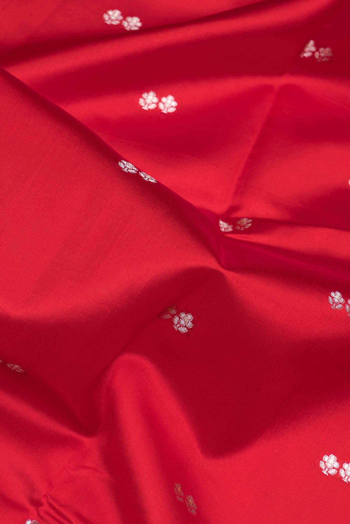 Close up of Red Dual Tone Tussar Silk Saree with Zari Butta on the body and Fancy Border.  displaying folds