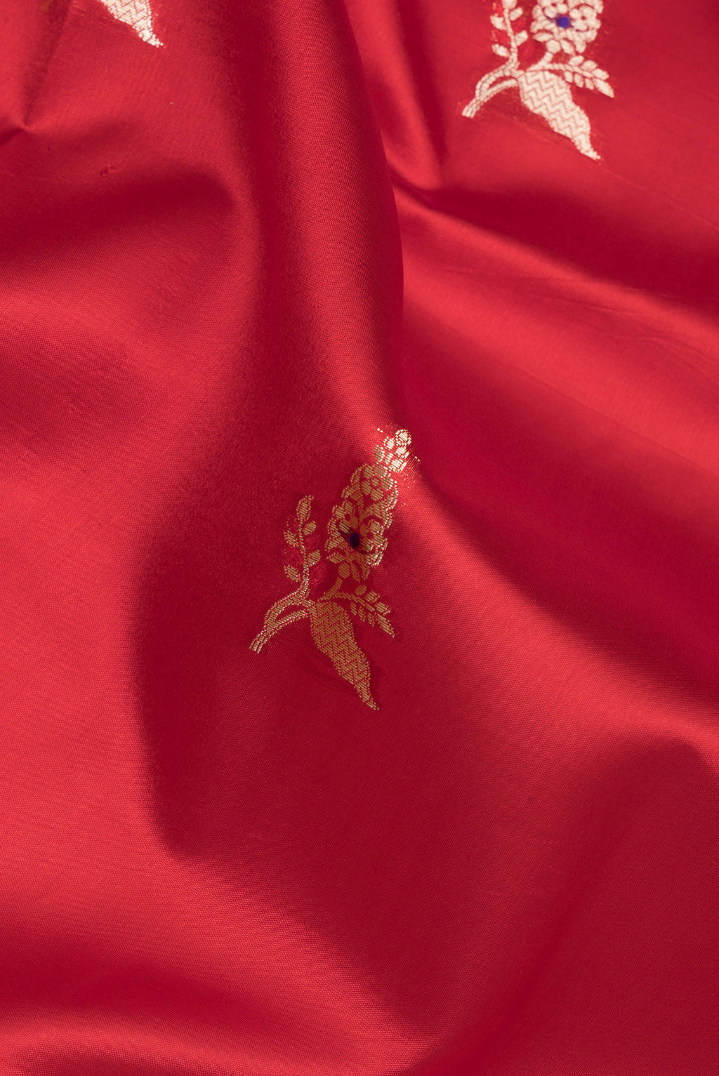 Close up of Pure Silk Maroon Dual Tone Tussar Saree with Zari Butta on the body and Fancy Border.  displaying folds