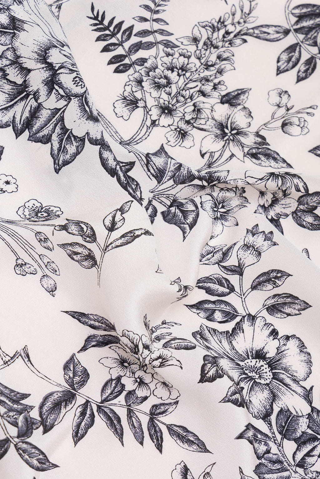 Close up of Off White Dual Tone Crepe Saree with Printed design on the body and Printed Border.  displaying folds