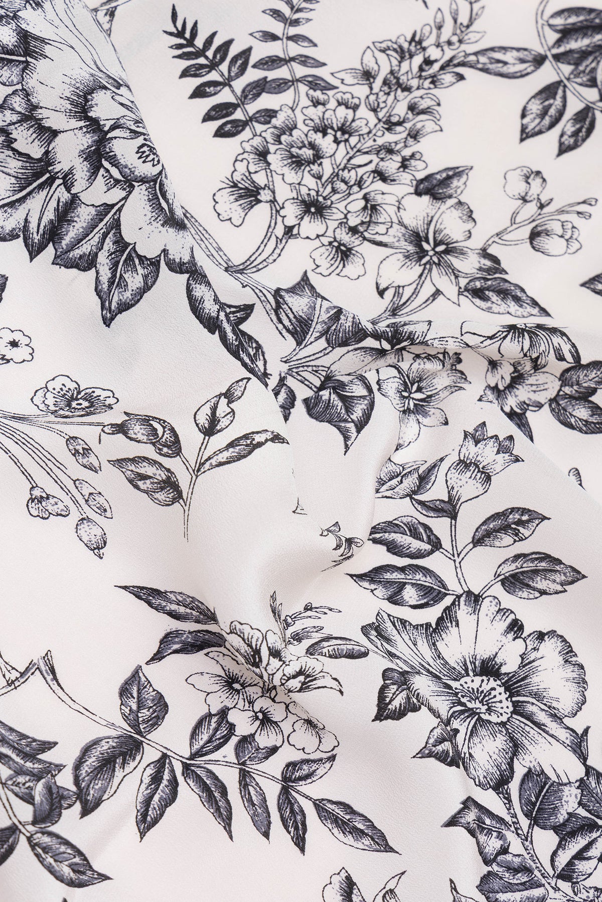 Close up of Off White Dual Tone Crepe Saree with Printed design on the body and Printed Border.  displaying folds