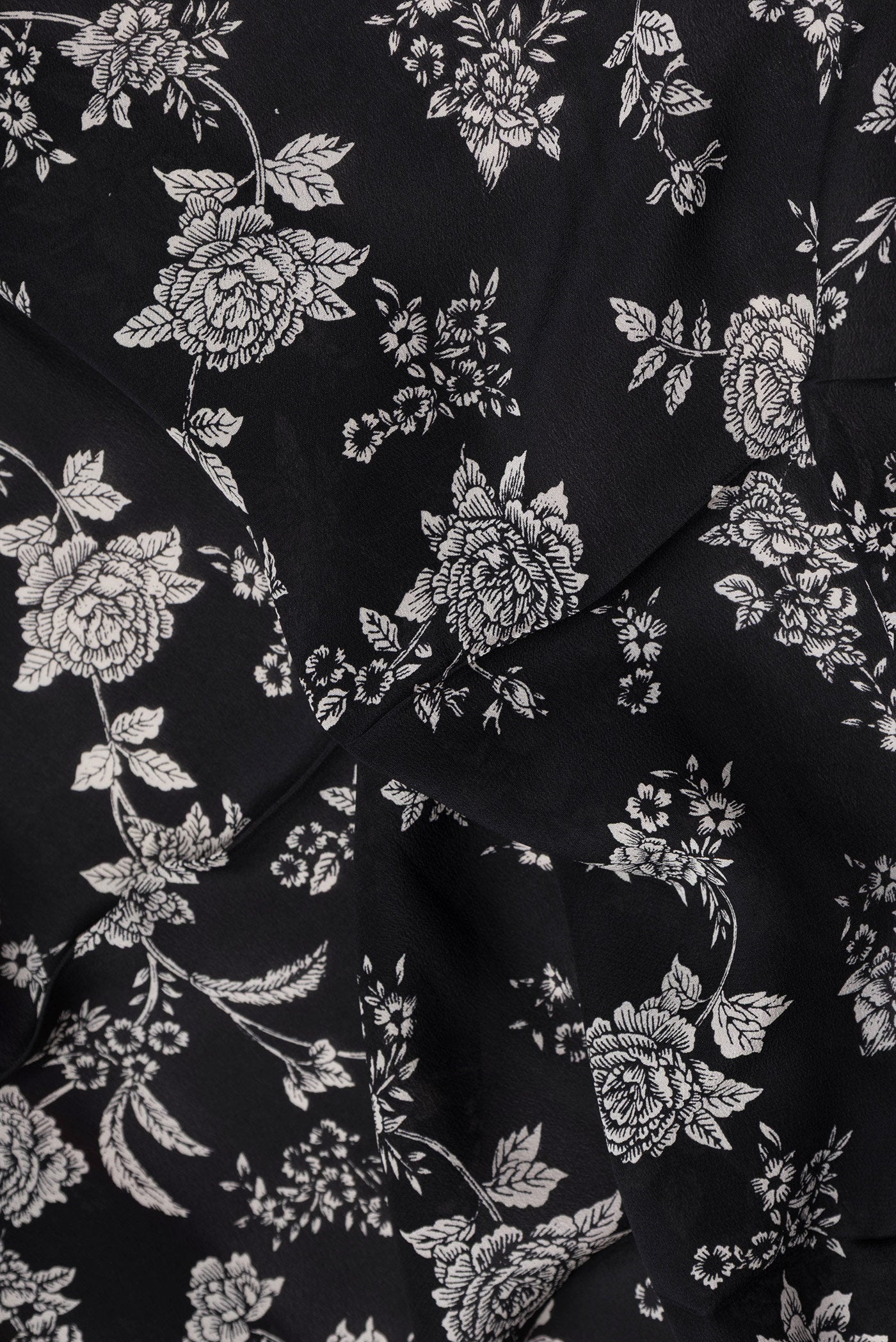 Close up of Black Dual Tone Mysore Crepe Saree with Printed design on the body and Plain Border.  displaying folds
