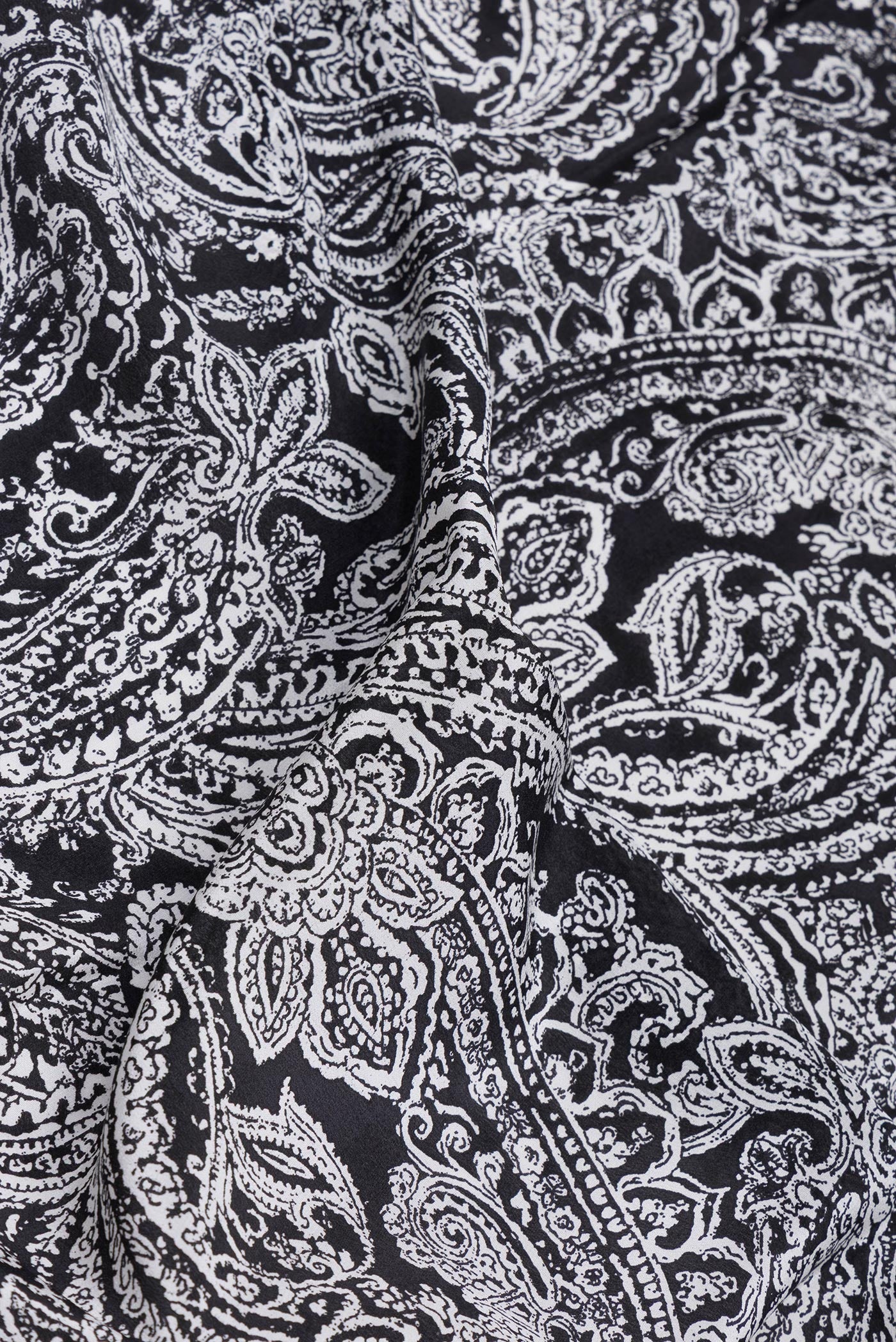 Close up of Black Crepe Saree with Printed design on the body and Printed Border.  displaying folds