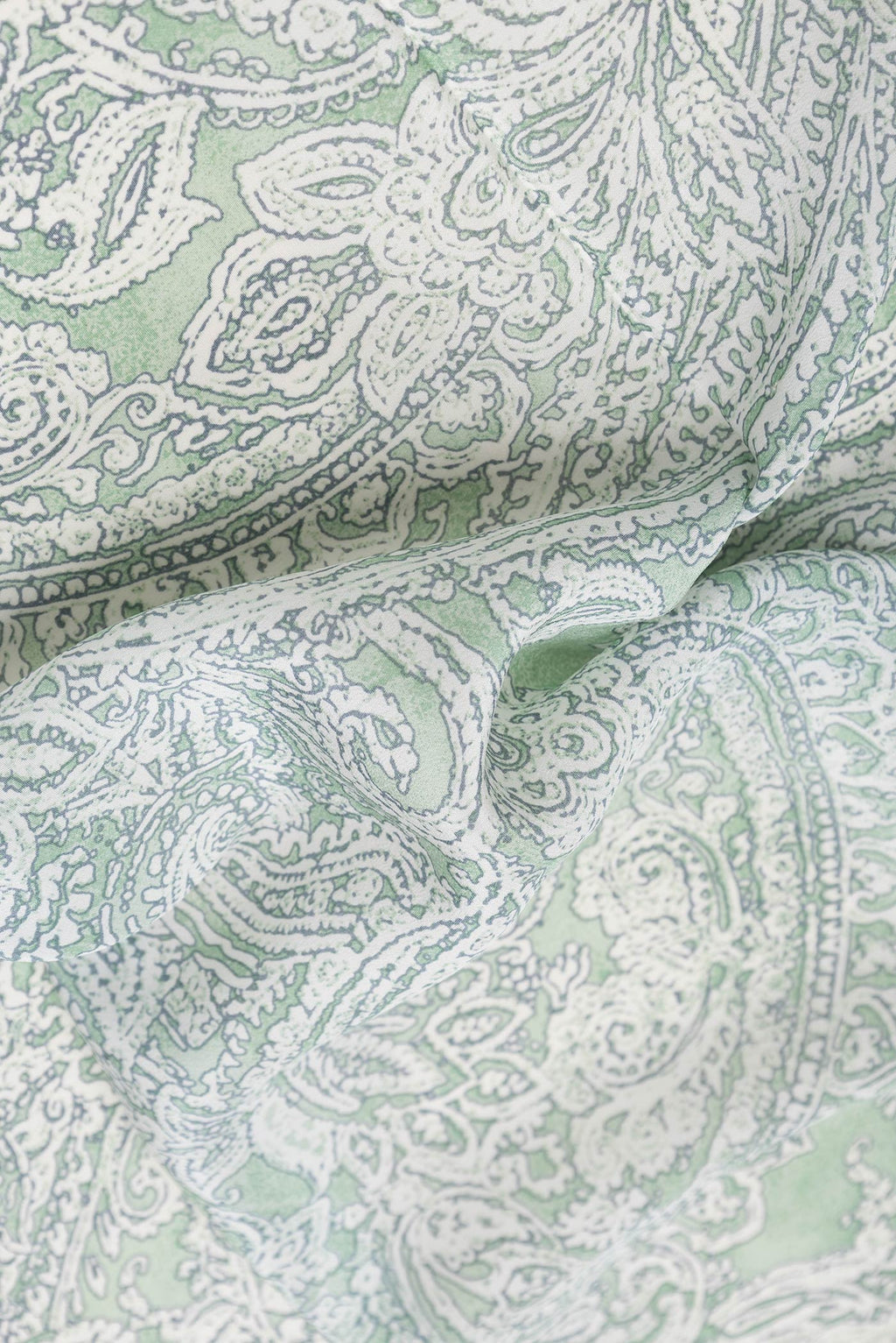 Close up of Pista Green Dual Tone Mysore Crepe Saree with Printed design on the body and Printed Border.  displaying folds