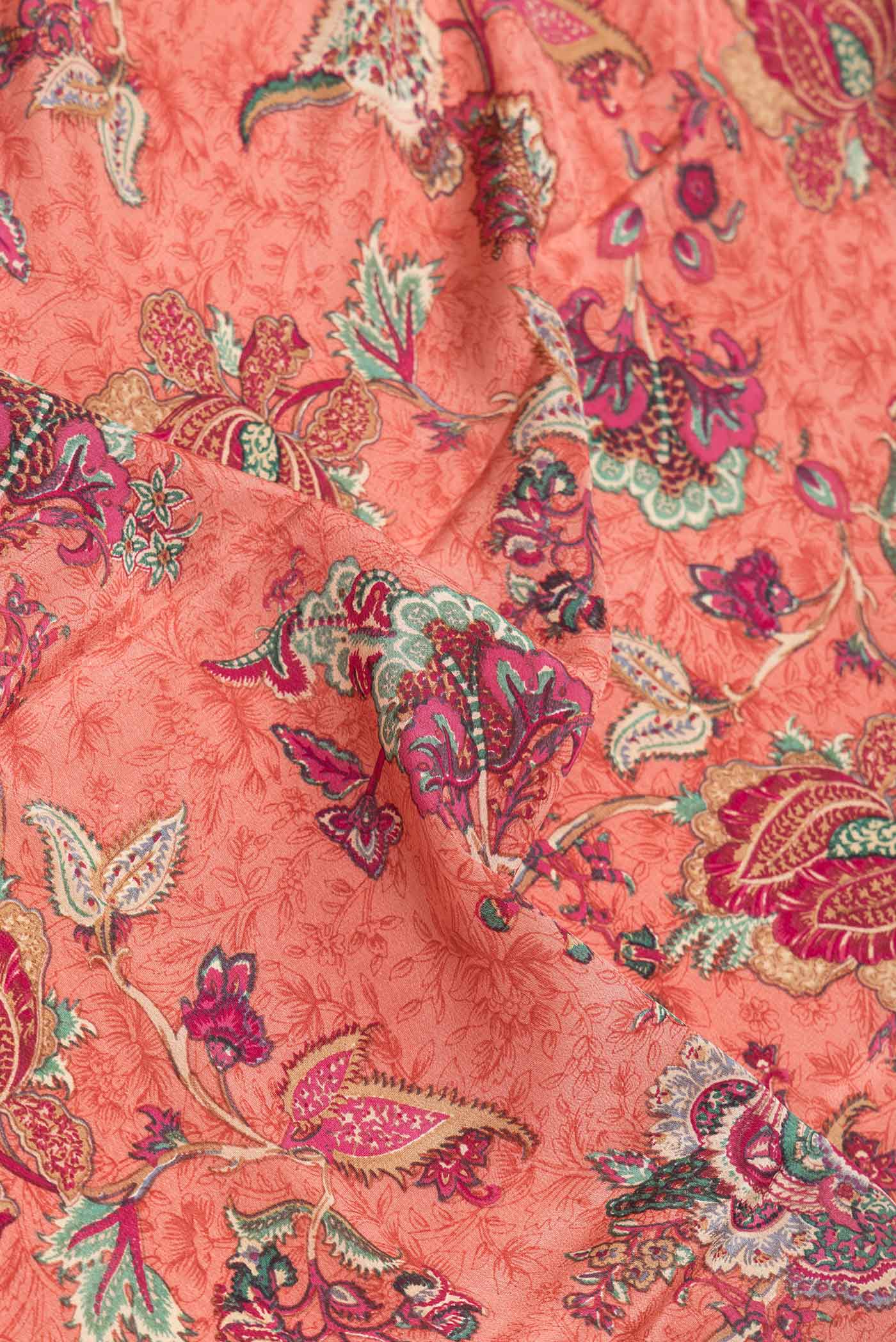 Close up of Peach Dual Tone Mysore Crepe Saree with Printed design on the body and Printed Border.  displaying folds