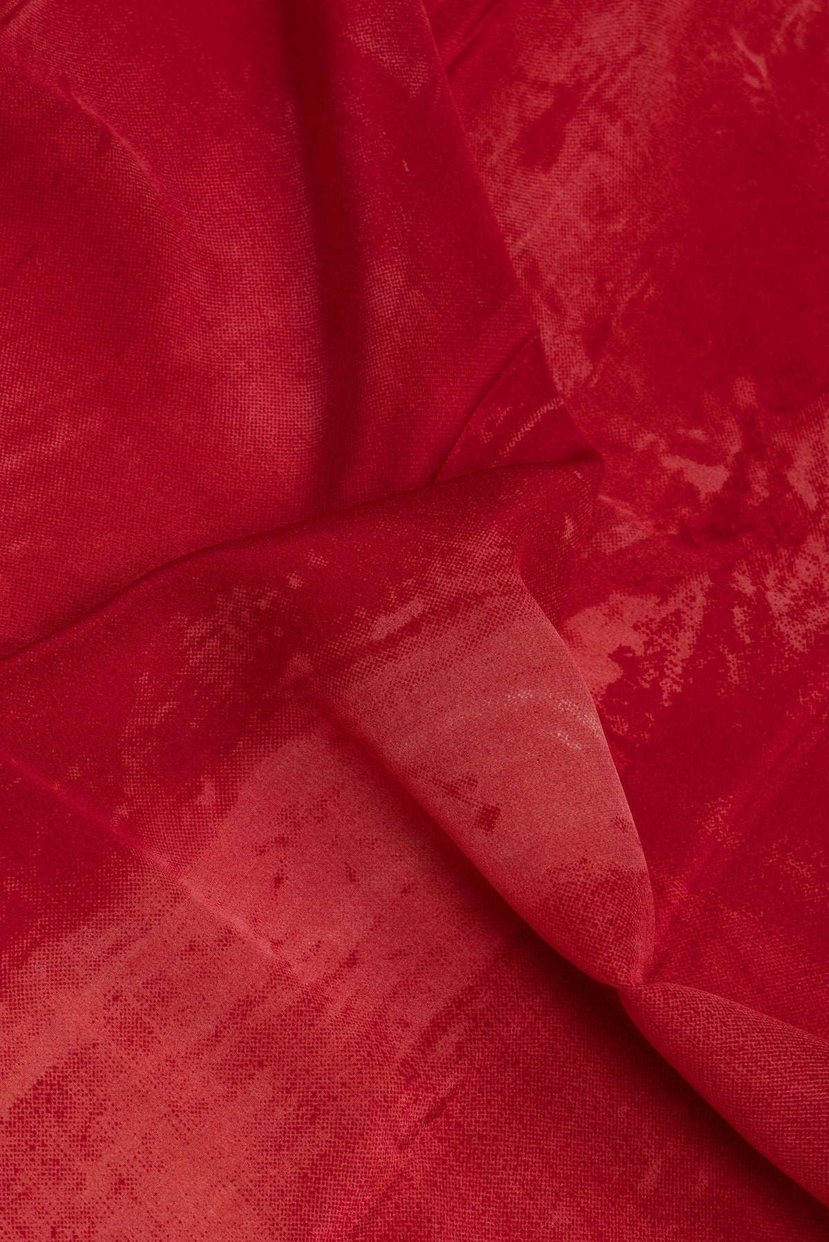 Close up of Red Crepe Saree with Printed design on the body and Plain Border.  displaying folds