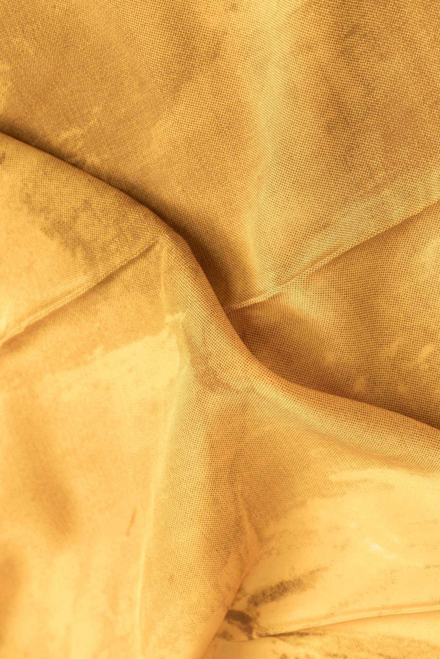 Close up of Mustard Dual Tone Mysore Crepe Saree with Printed design on the body and Plain Border.  displaying folds