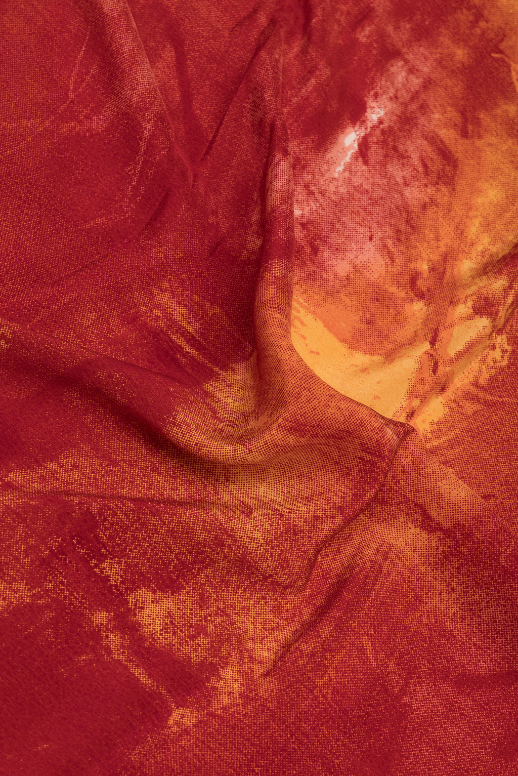 Close up of Rust Crepe Saree with Printed design on the body and Plain Border.  displaying folds