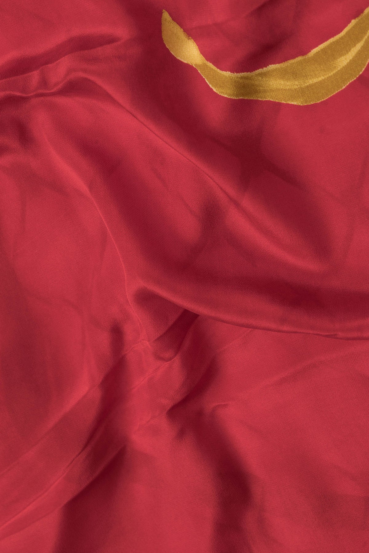 Close up of Red Dual Tone Mysore Crepe Saree with Printed design on the body and Plain Border.  displaying folds