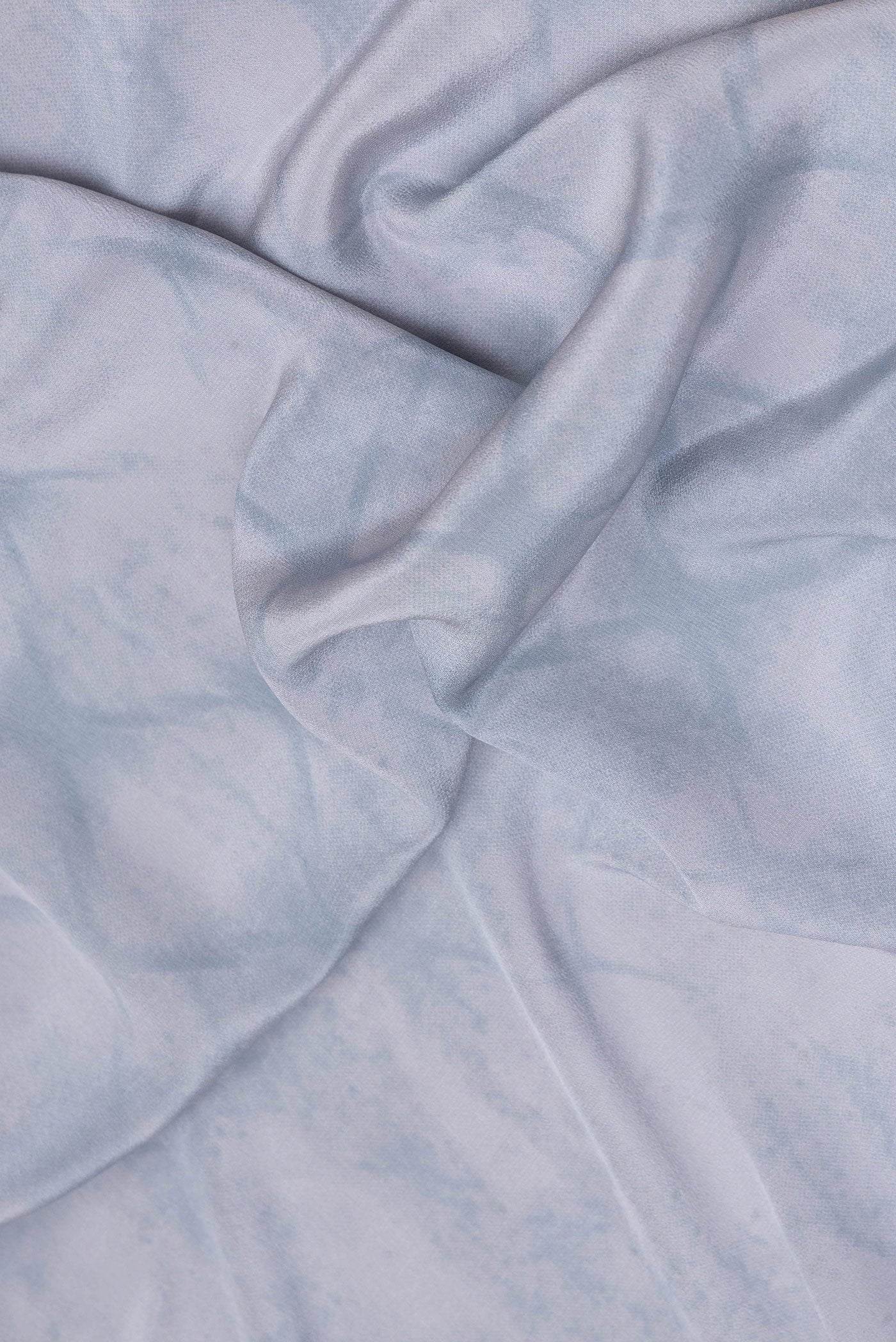 Close up of Grey Crepe Saree with Printed design on the body and Plain Border.  displaying folds