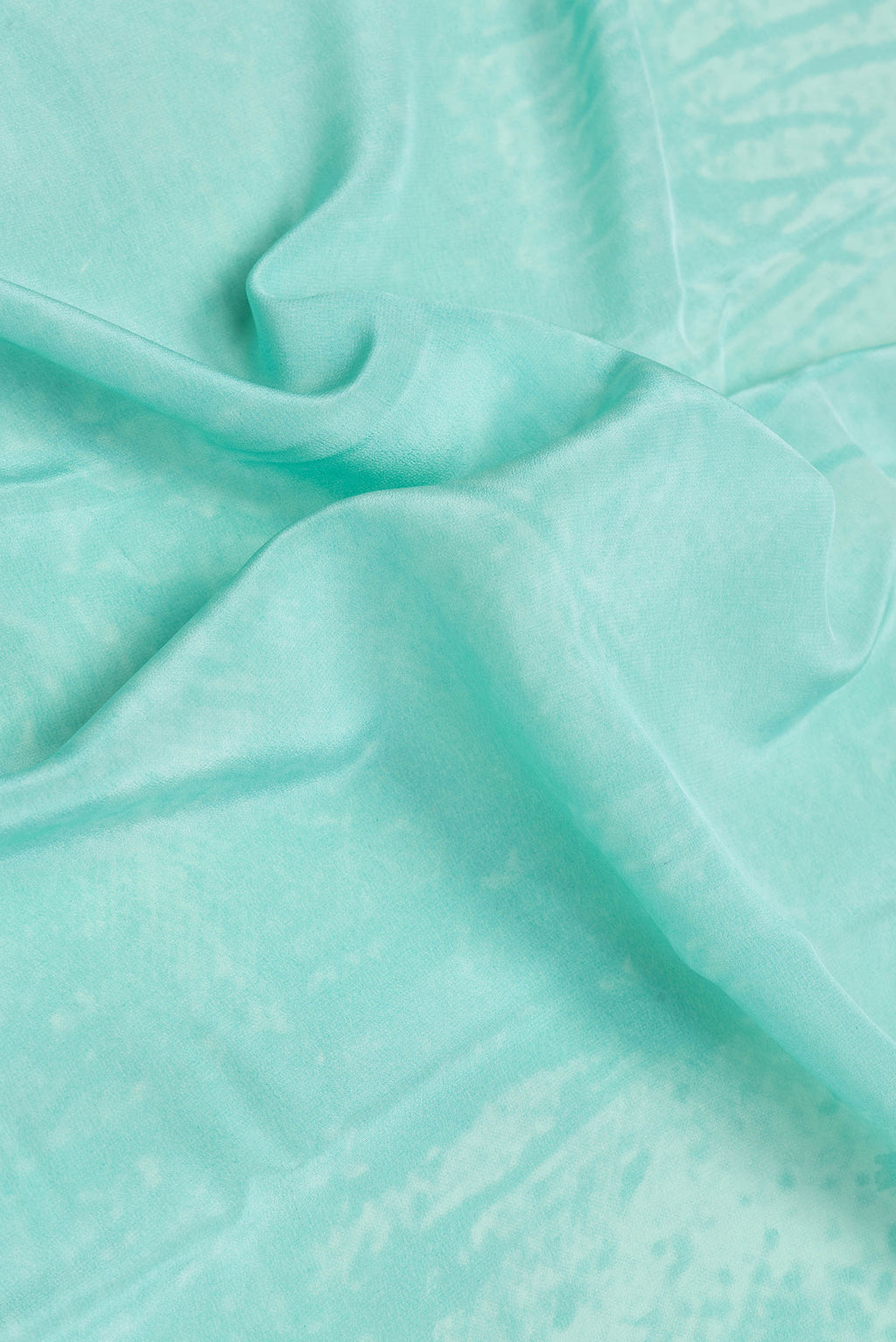 Close up of Sky Blue Dual Tone Mysore Crepe Saree with Printed design on the body and Plain Border.  displaying folds