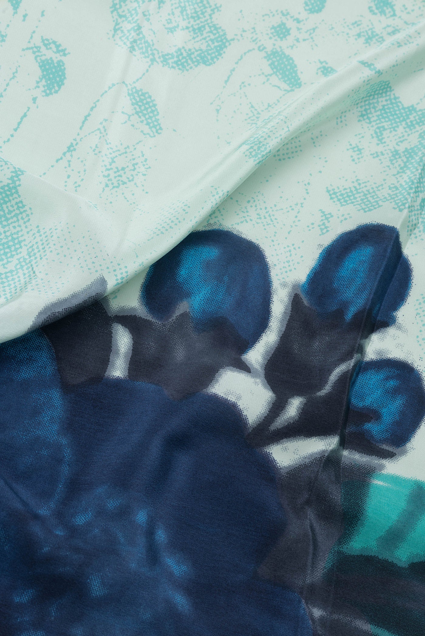 Close up of Pista Green Dual Tone Crepe Saree with Printed design on the body and Plain Border.  displaying folds
