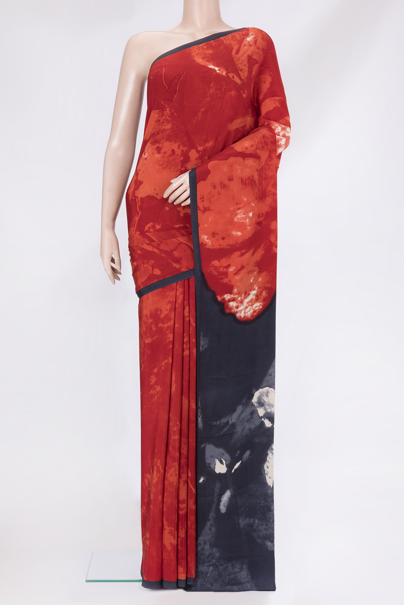 Red Crepe Saree with Printed design on the body and Plain Border.  displayed on a mannequin