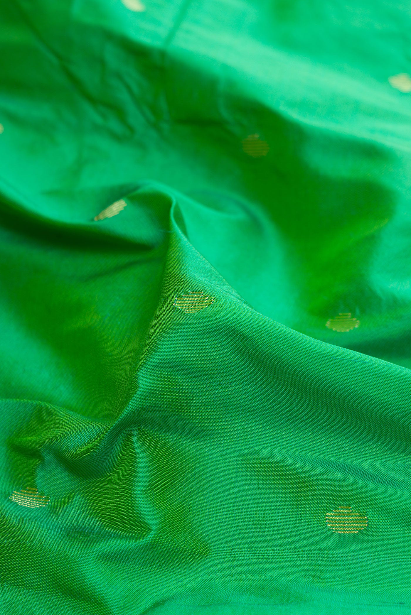 Close up of Light Green Paithani Silk Saree with Zari Butta on the body and Paithani Border.  displaying folds