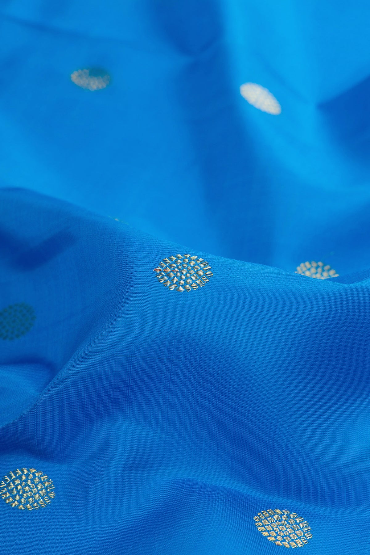 Close up of Pure Silk Sky Blue Kanjivaram Saree with Zari Butta on the body and Zari Border.  displaying folds