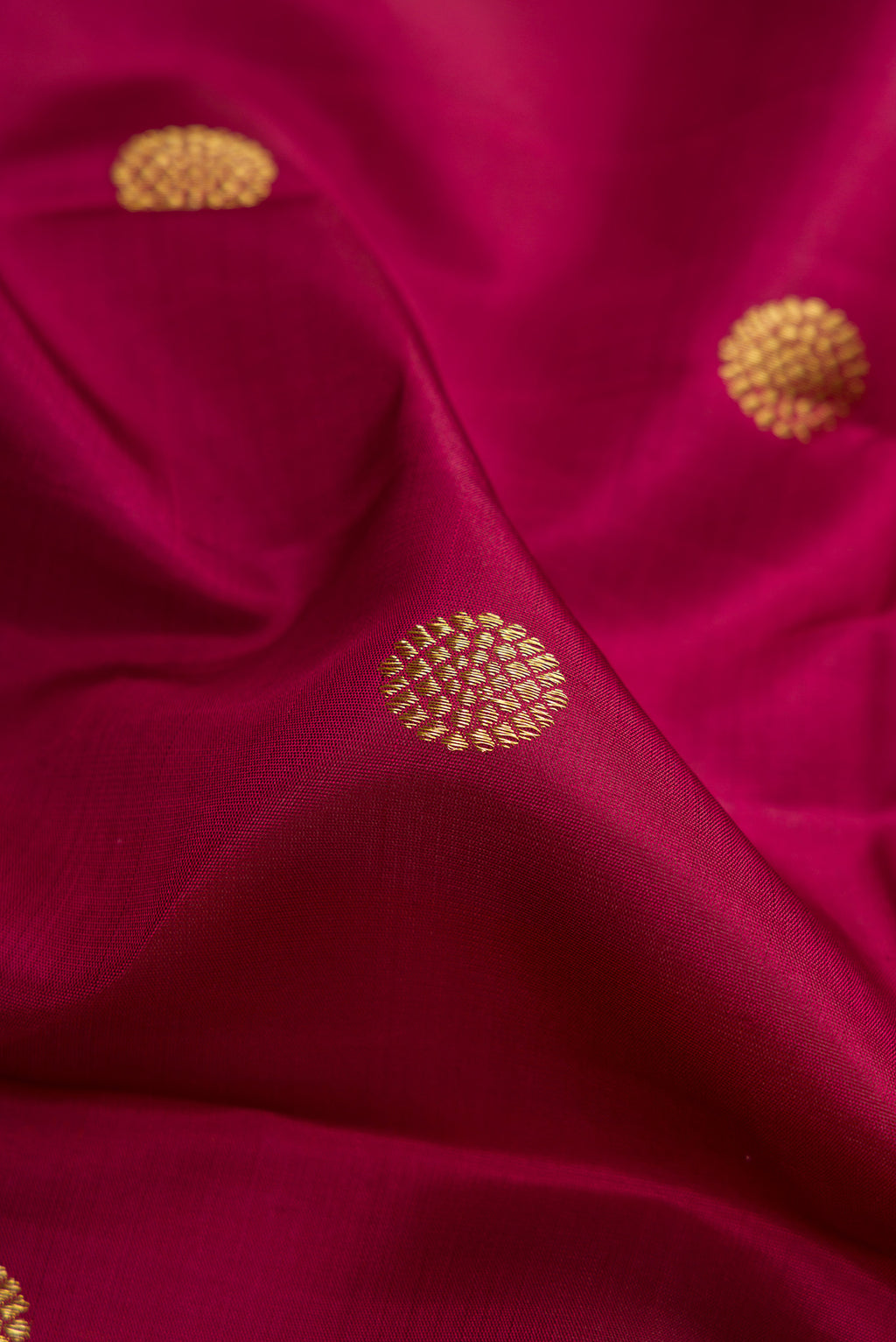 Close up of Maroon Kanjivaram Silk Saree with Zari Butta on the body and Zari Border.  displaying folds