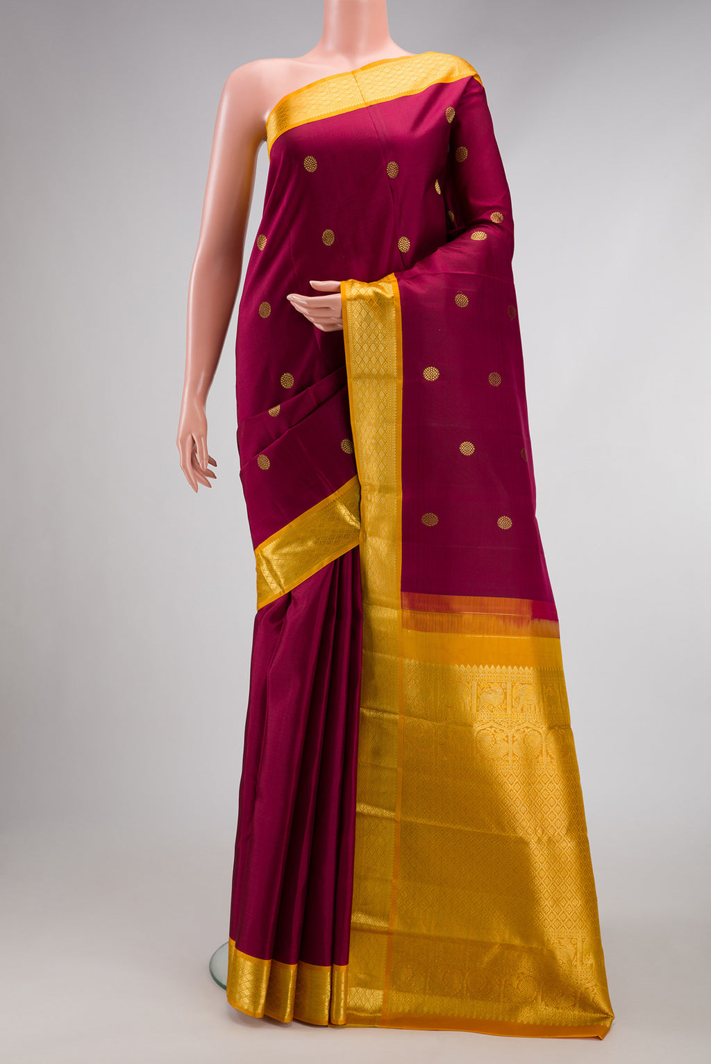 Maroon Kanjivaram Silk Saree with Zari Butta on the body and Zari Border.  displayed on a mannequin