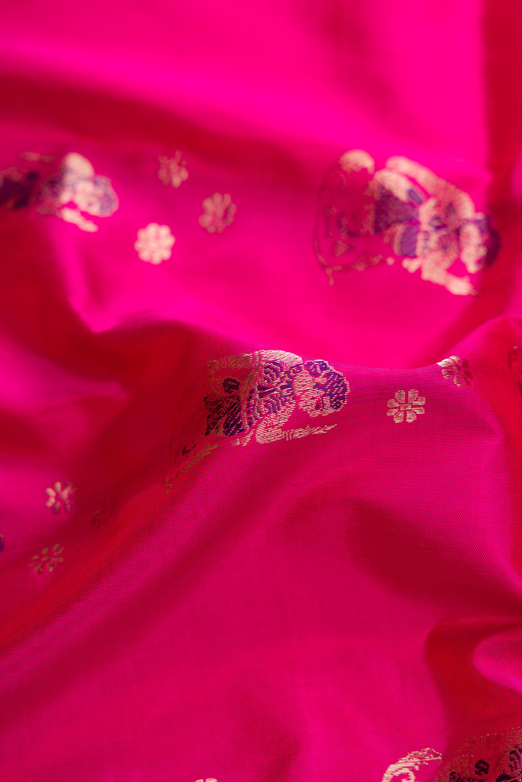 Close up of Pink Dual Tone Baluchari Silk Saree with Zari And Thread Butta on the body and Zari Border.  displaying folds