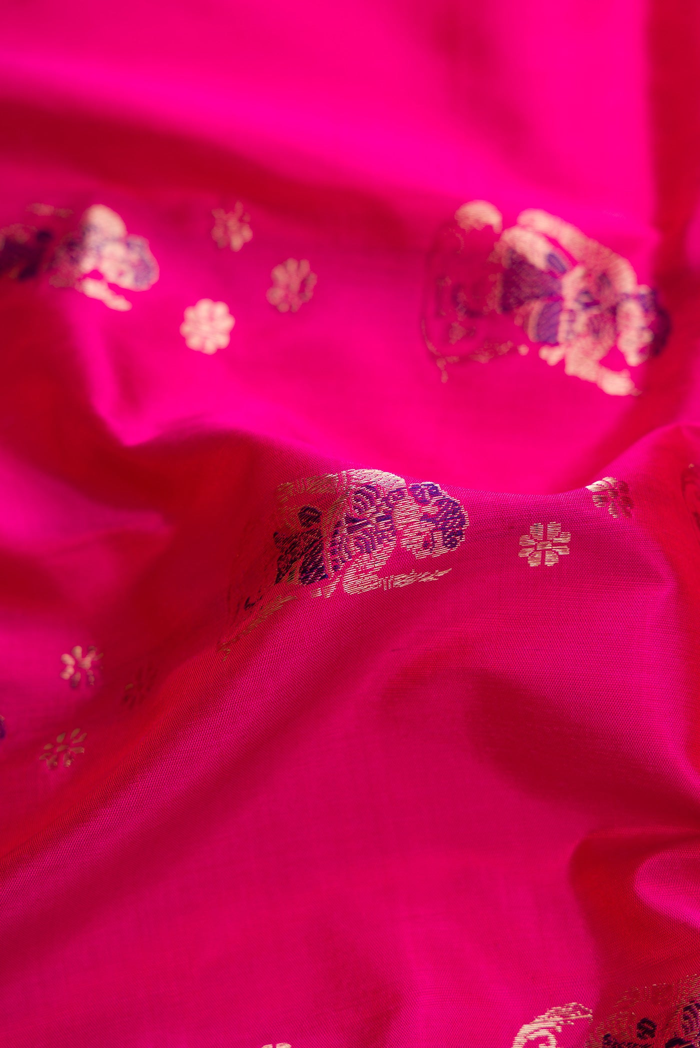 Close up of Pink Dual Tone Baluchari Silk Saree with Zari And Thread Butta on the body and Zari Border.  displaying folds