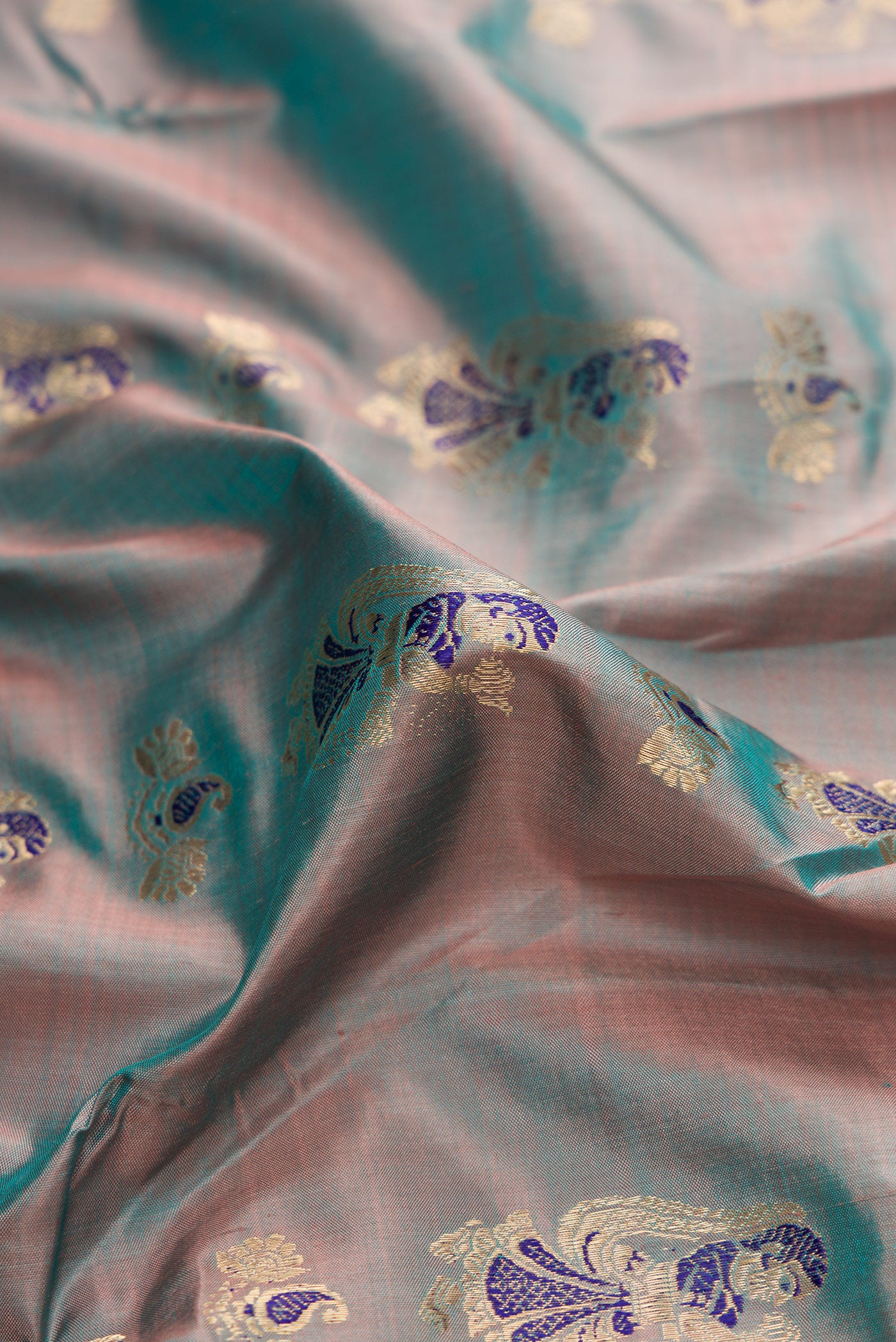 Close up of Blue Grey Dual Tone Baluchari Silk Saree with Zari And Thread Butta on the body and Fancy Border.  displaying folds