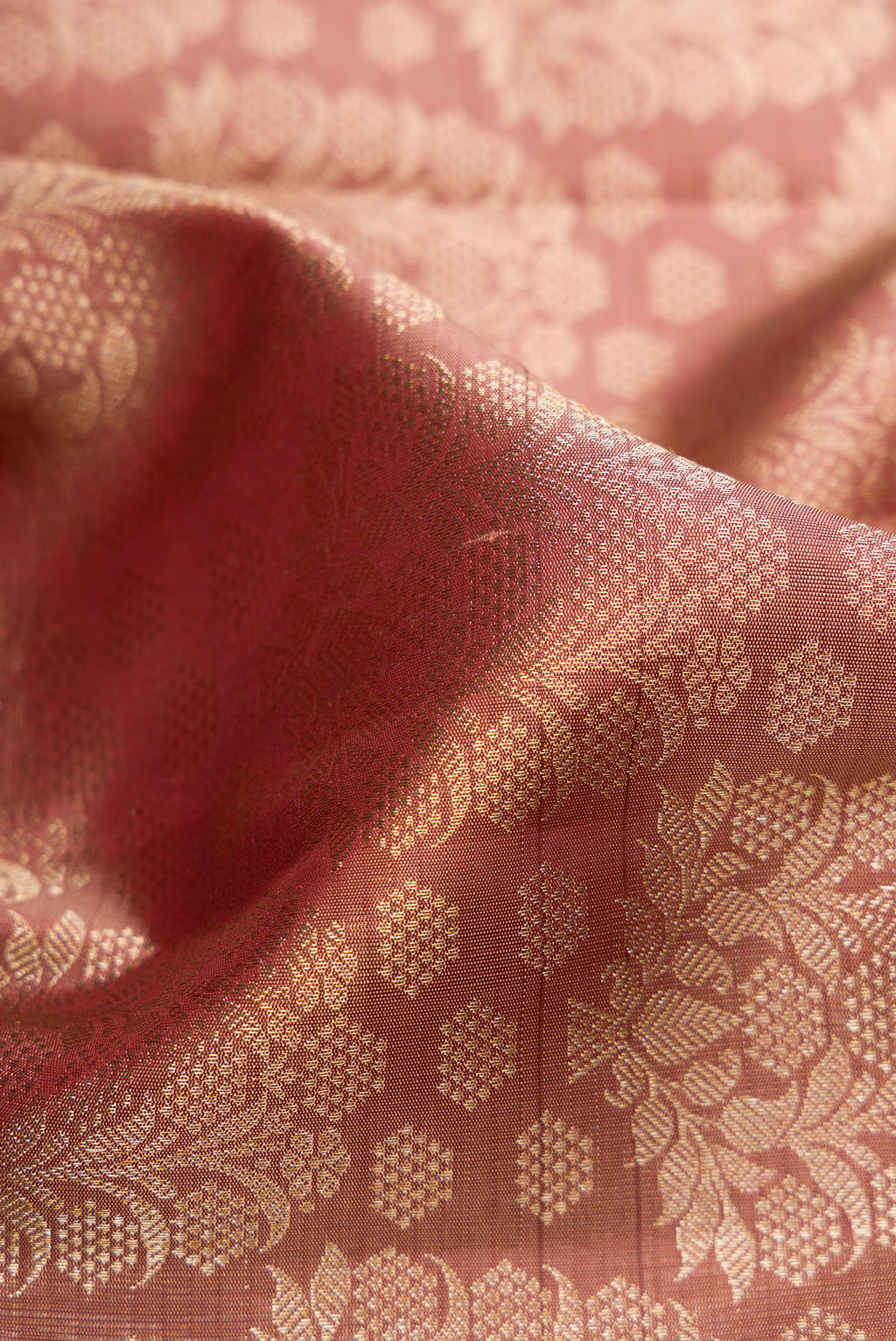 Close up of Rose Gold Dual Tone Kanchipuram Silk Saree with Zari Brocade on the body and Zari Border.  displaying folds