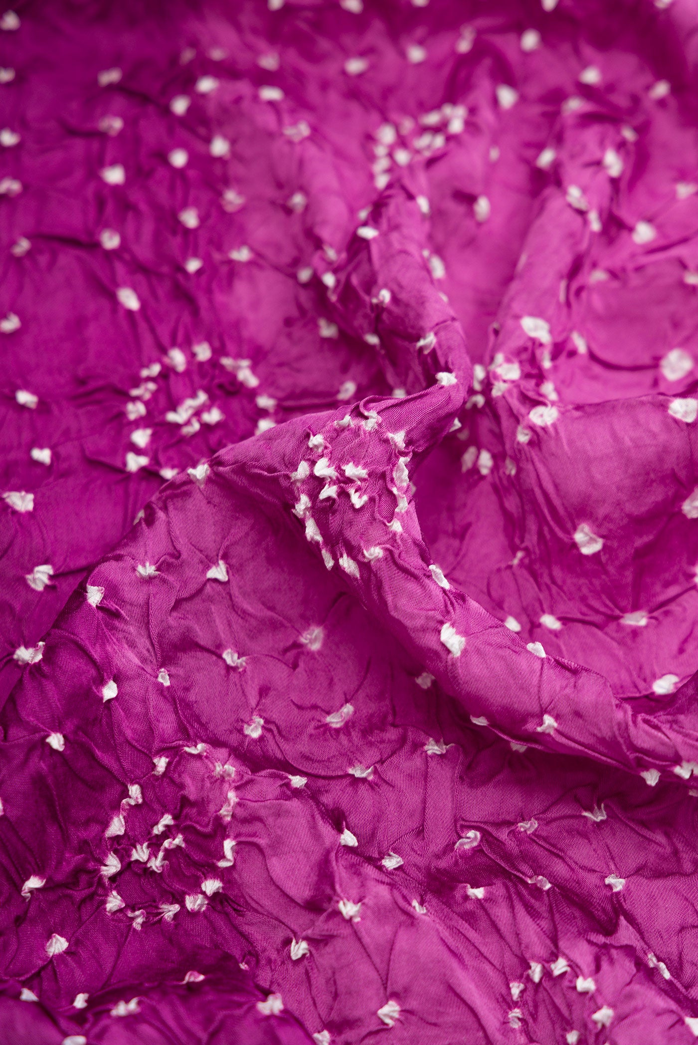 Close up of Purple Dual Tone Bandhani Silk Saree with Printed design on the body and Printed Border.  displaying folds
