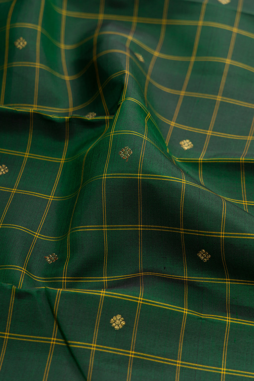 Close up of Bottle Green Kanchipuram Silk Saree with Checked design on the body and Thin Zari Line.  displaying folds