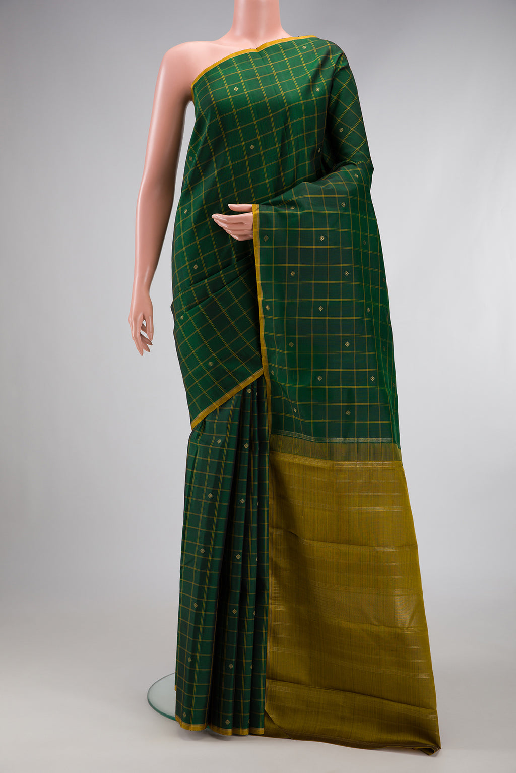 Bottle Green Kanchipuram Silk Saree with Checked design on the body and Thin Zari Line.  displayed on a mannequin