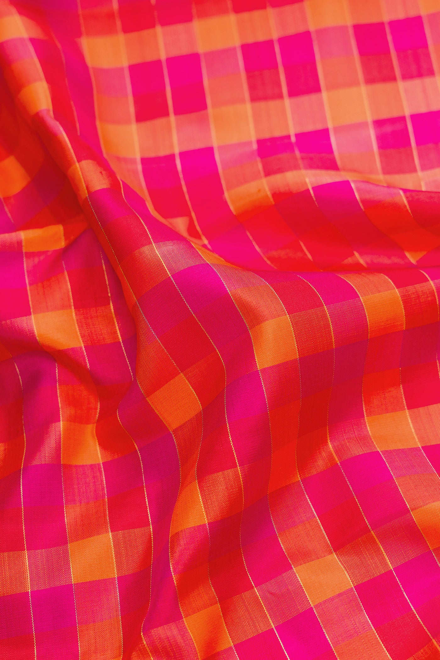 Close up of Pure Silk Pure Zari Red, Pink and Maroon Color Kanchipuram Saree with Checked design on the body and Zari Border.  displaying folds
