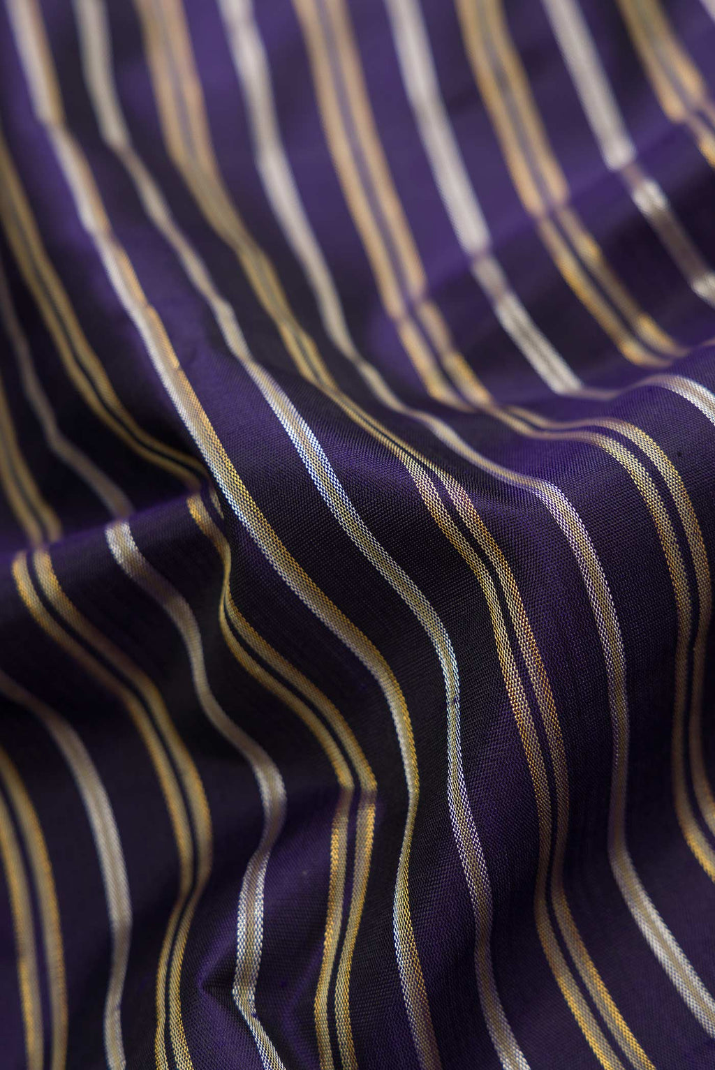 Close up of Navy Blue Dual Tone Kanchipuram Silk Saree with Stripes on the body and Zari Border.  displaying folds