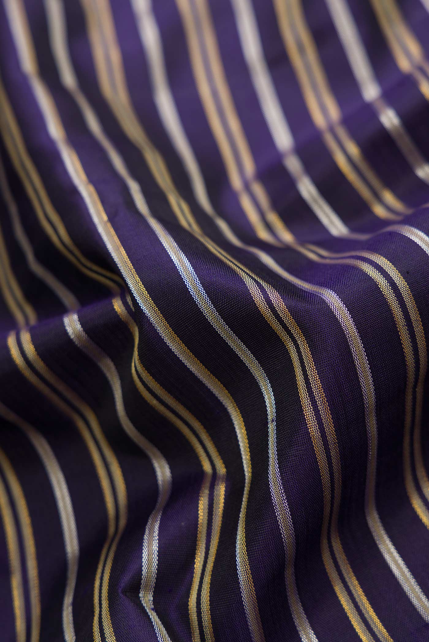 Close up of Navy Blue Dual Tone Kanchipuram Silk Saree with Stripes on the body and Zari Border.  displaying folds