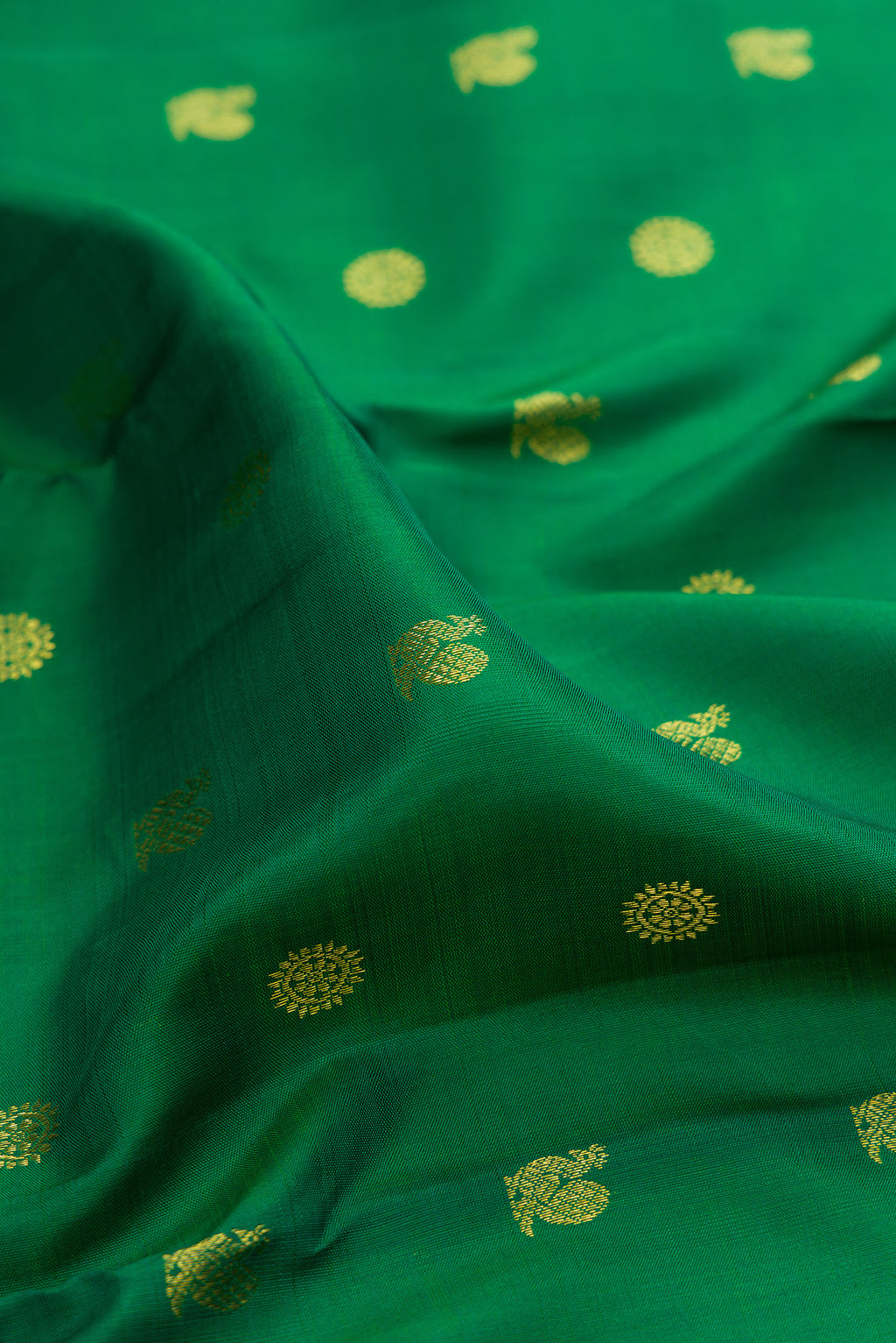 Close up of Green Kanjivaram Silk Saree with Zari Butta on the body and Zari Border.  displaying folds